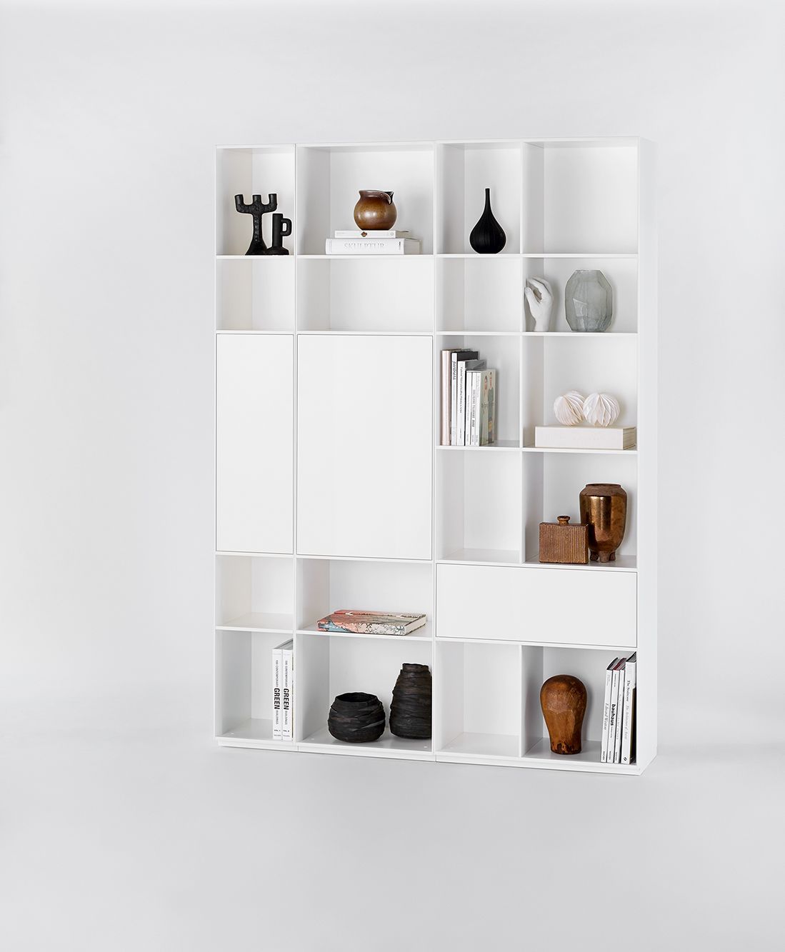 Weißes Nex Pur Regal von Piure mit Tür, Fachboden und dekorativen Objekten.