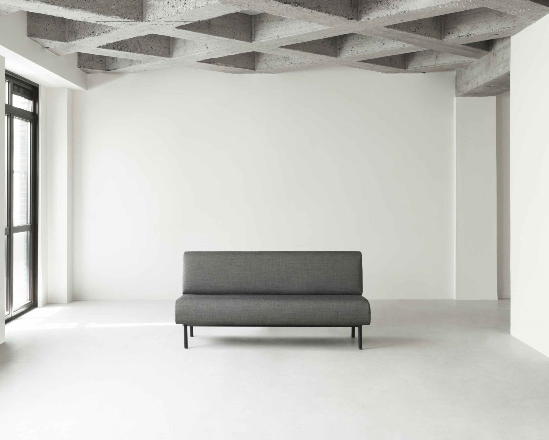 Graues Fram Sofa von Normann Copenhagen, 165 cm, im minimalistischen Raum mit Betonstruktur.