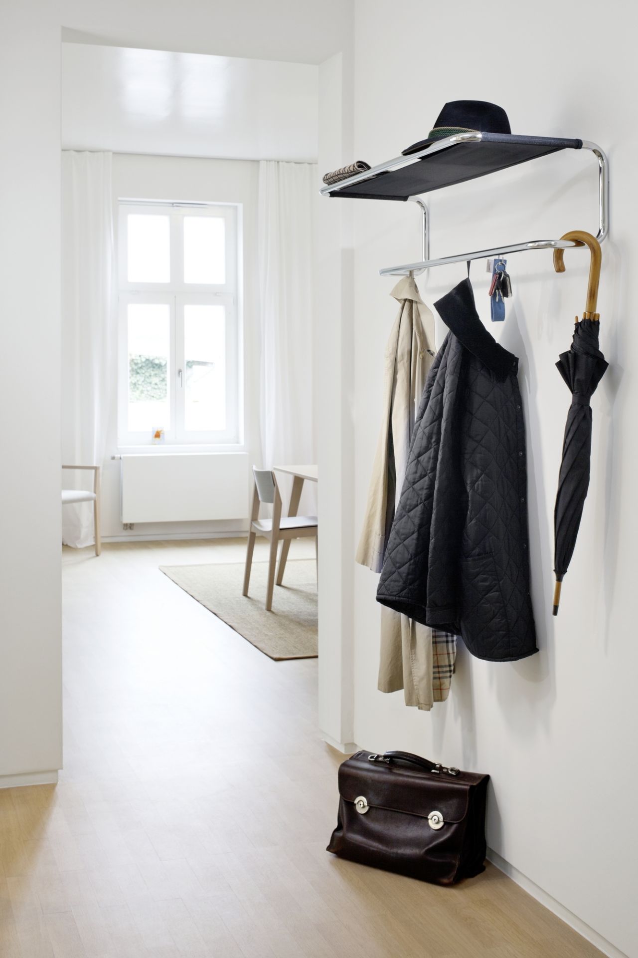 Thonet Wandgarderobe S 1520 mit Kleidung, Regenschirm und Tasche im minimalistischen Flur. Design Garderoben für stilvolle Ordnung.