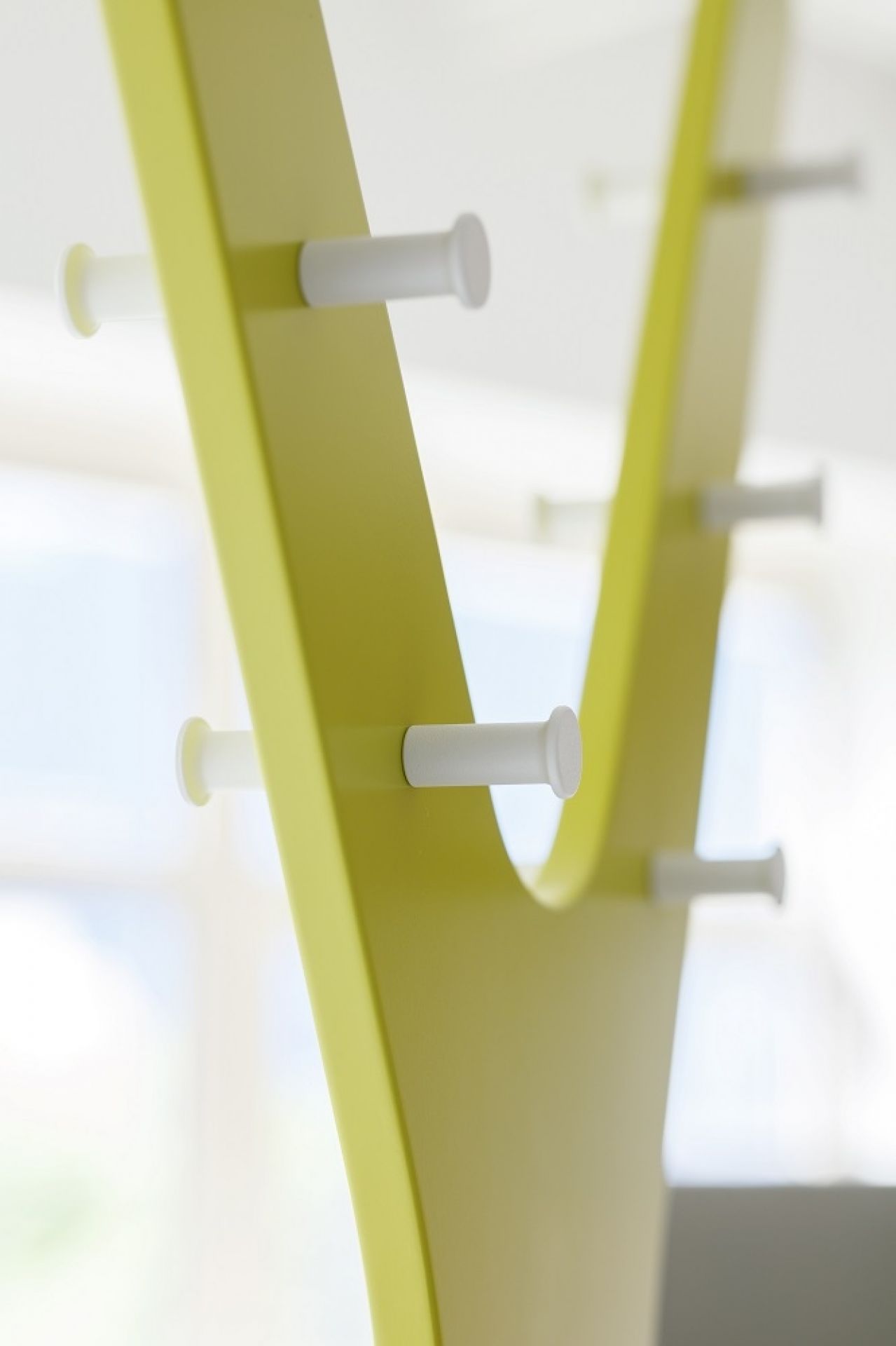 Nahaufnahme der modernen, gelben Tree Standgarderobe von Cascando mit weißen Haken für Jacken und Mäntel.