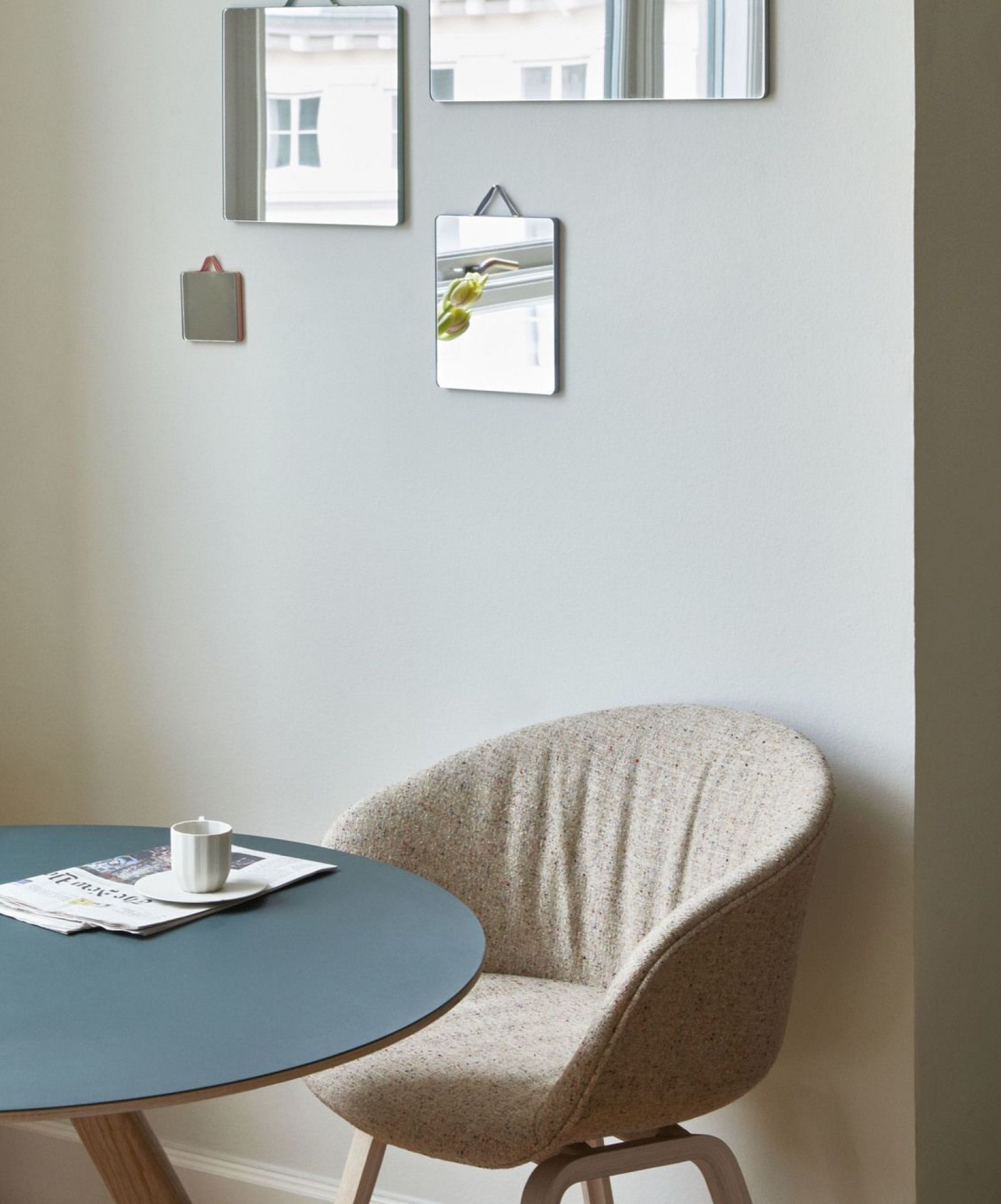 Beiger About a Chair AAC23 Stuhl von Hay am Esstisch mit Zeitung und Tasse.