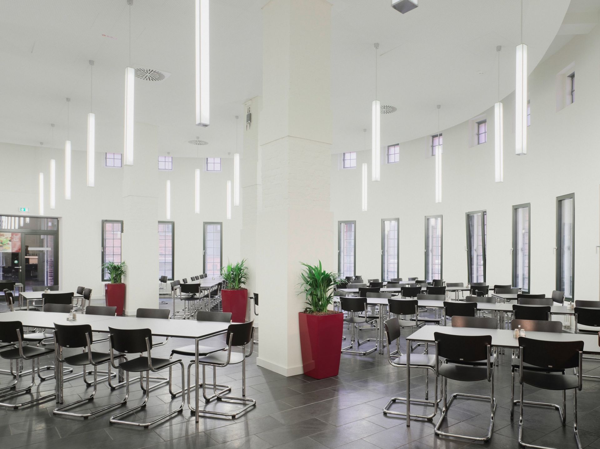 Innenraum mit vielen S 43 Stahlrohr Freischwinger Stühlen von Thonet an Tischen.