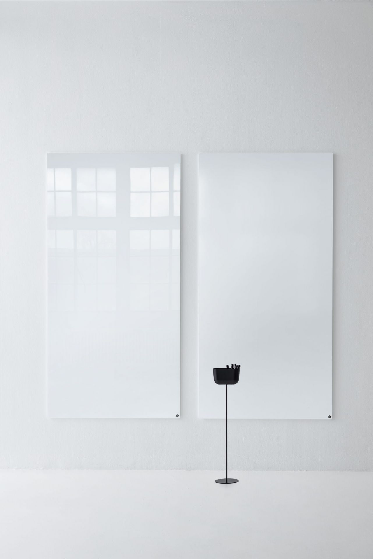 Zwei weiße, magnetische Chat Board Glastafeln an einer weißen Wand mit Stifthalter.