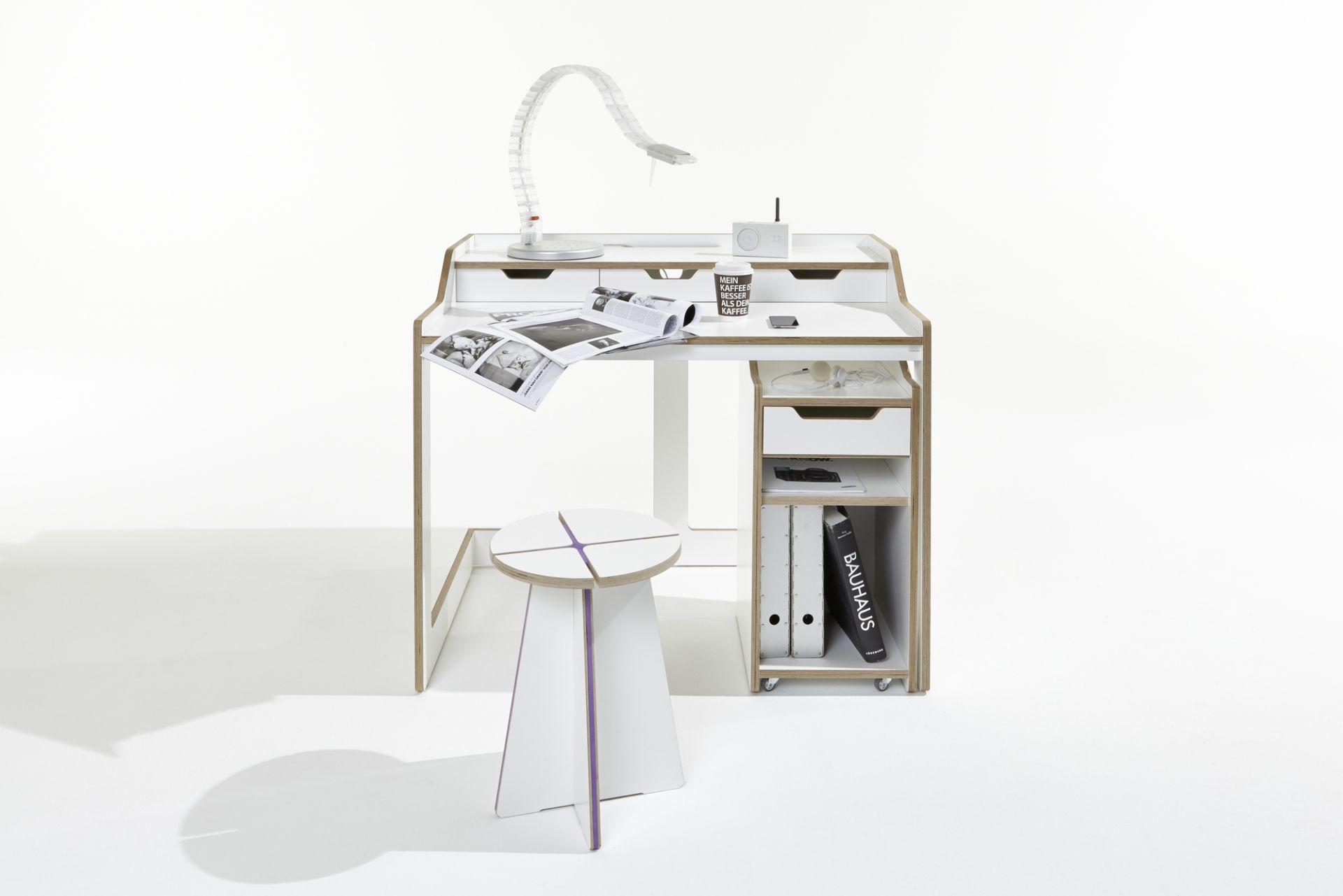 Weißer Schreibtisch mit Rollcontainer von Müller Möbelwerkstätten und passendem Hocker im modernen Design.