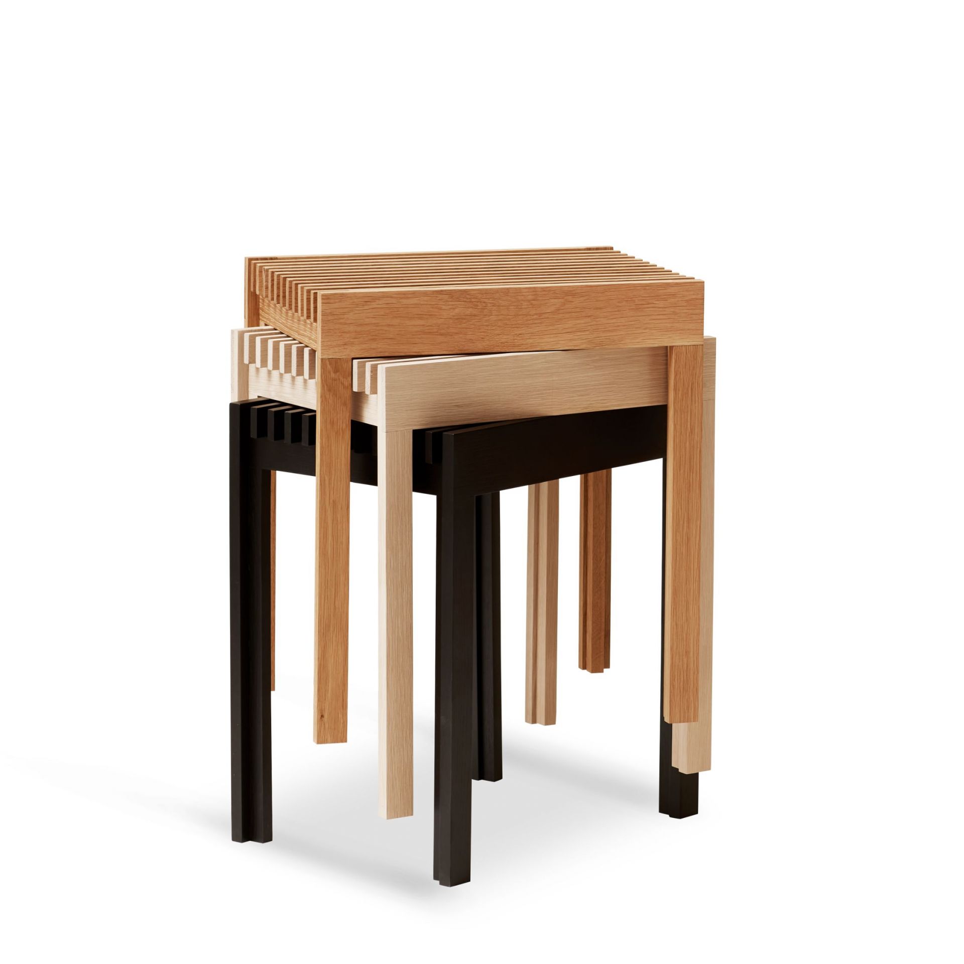 Drei Form & Refine Hocker aus Eiche in Natur, gebleicht und Schwarz gestapelt.