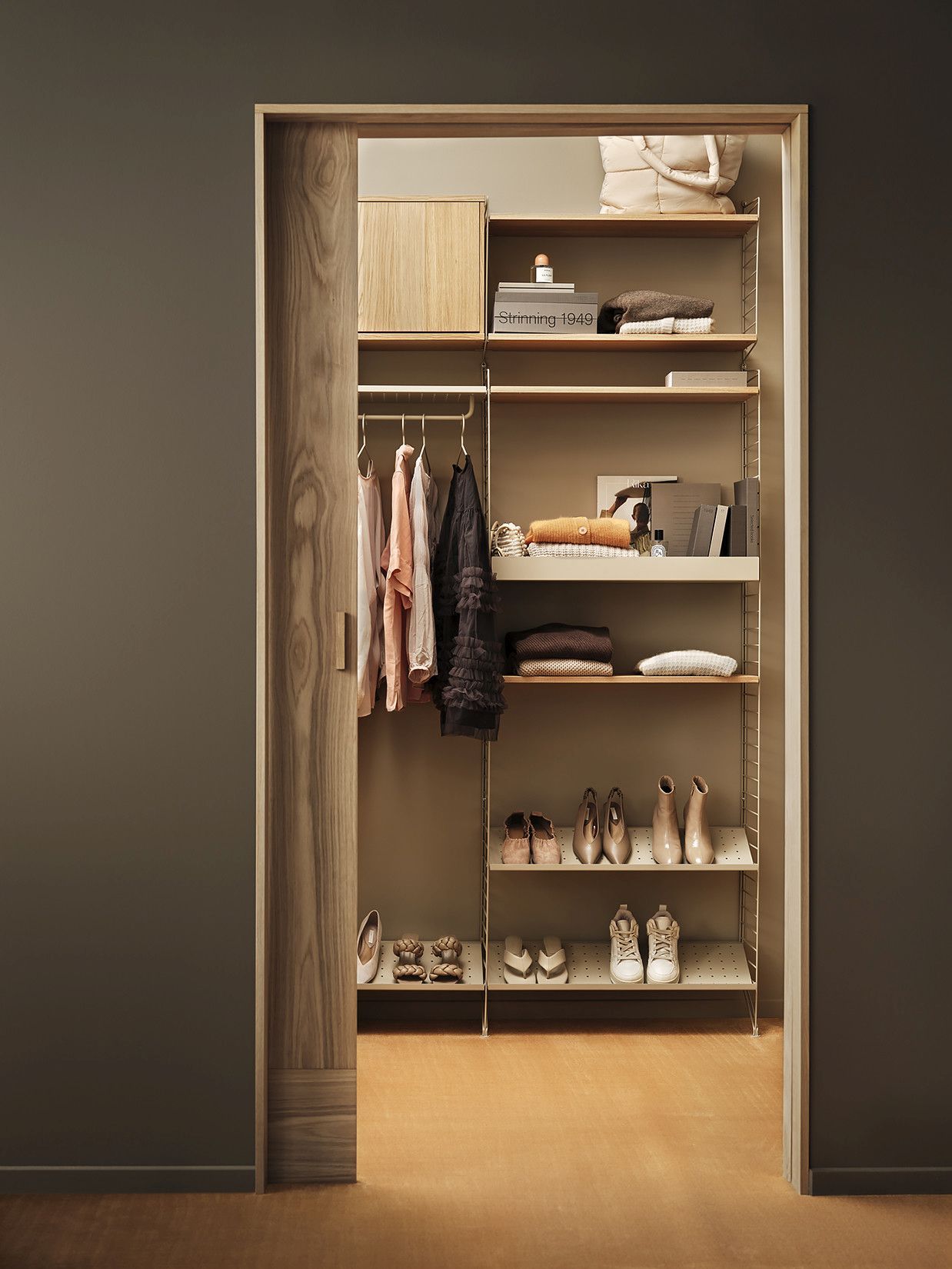 Schuhregal im begehbaren Kleiderschrank mit String Regalsystem. Schuhe auf der schwarzen String Furniture Schuhablage.