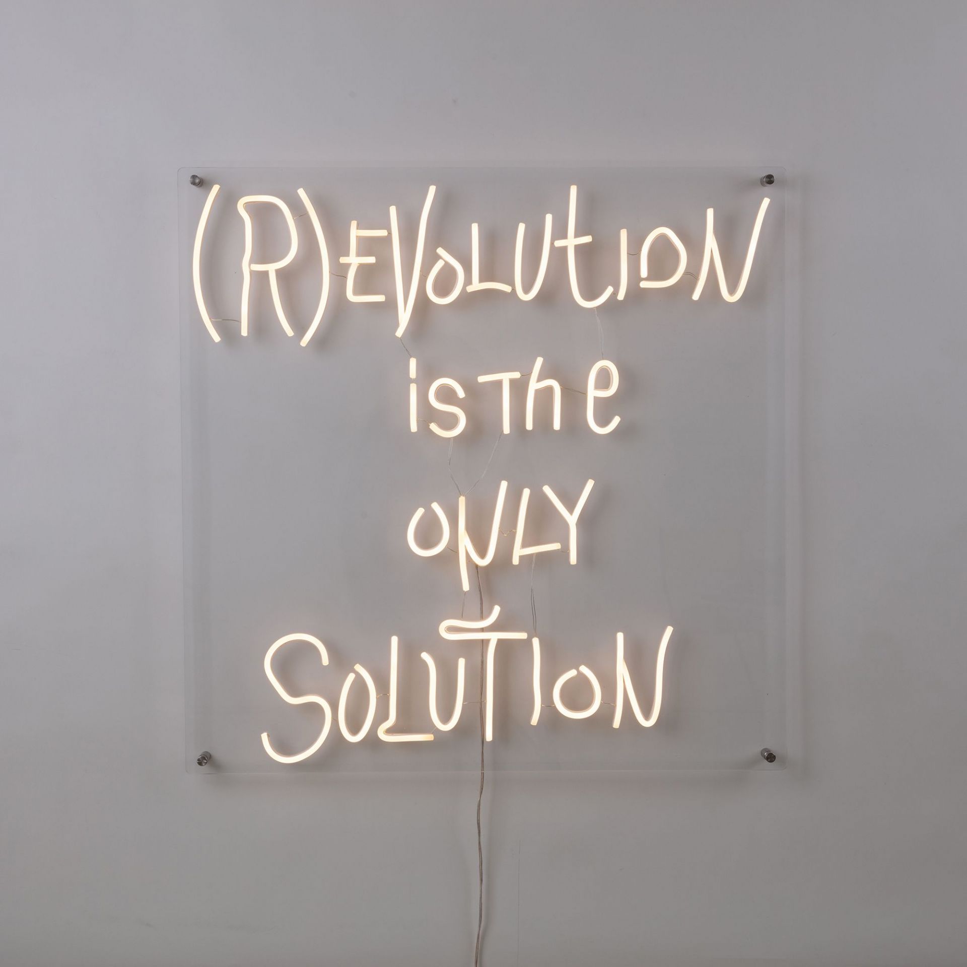 Seletti Revolution LED Wandleuchte: Neon-Schriftzug "Revolution is the only solution" auf transparentem Acryl.