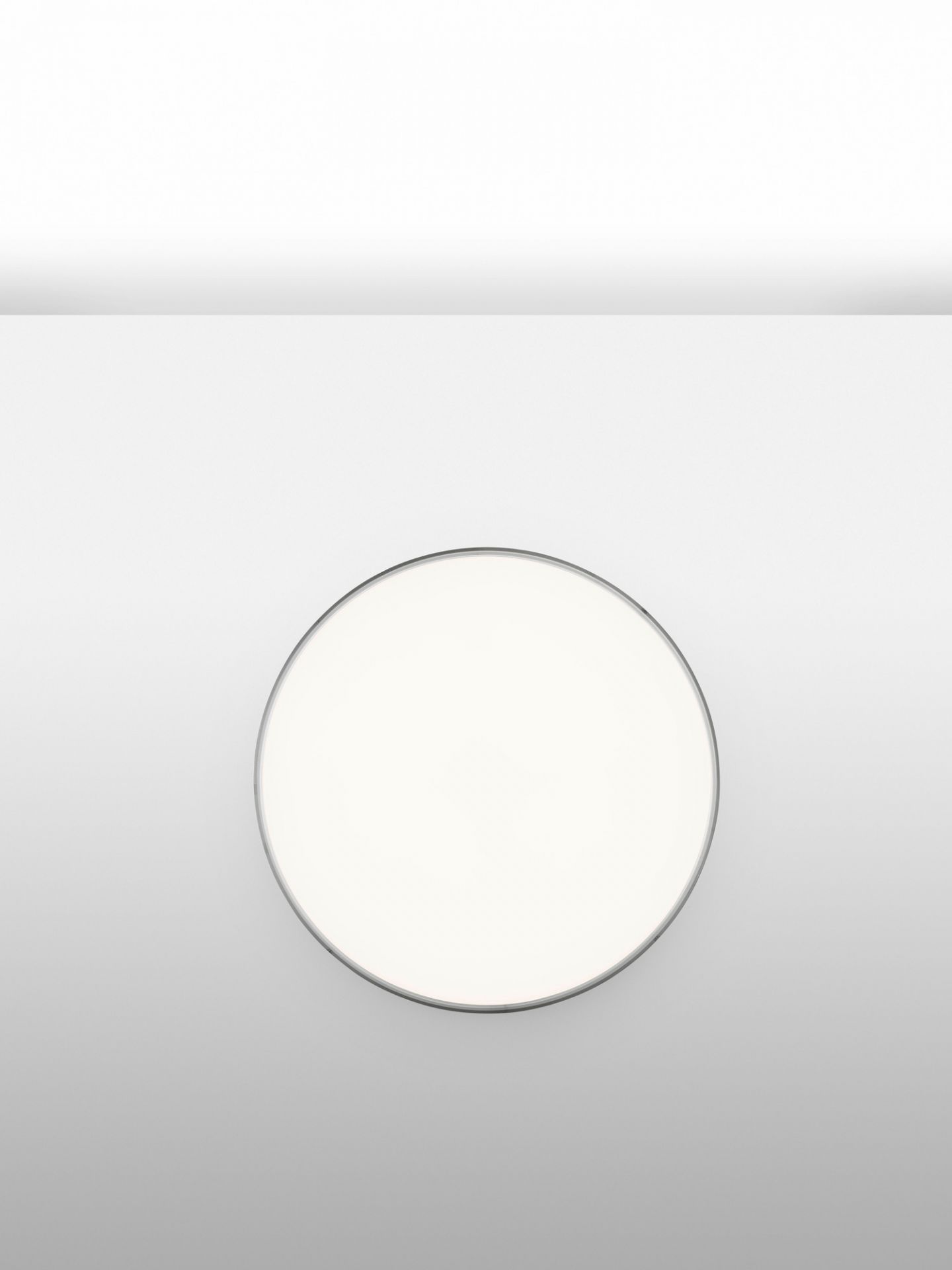 Nahaufnahme der runden Flos Clara Deckenleuchte mit silberfarbenem Ring. Wandleuchte für Innenräume.