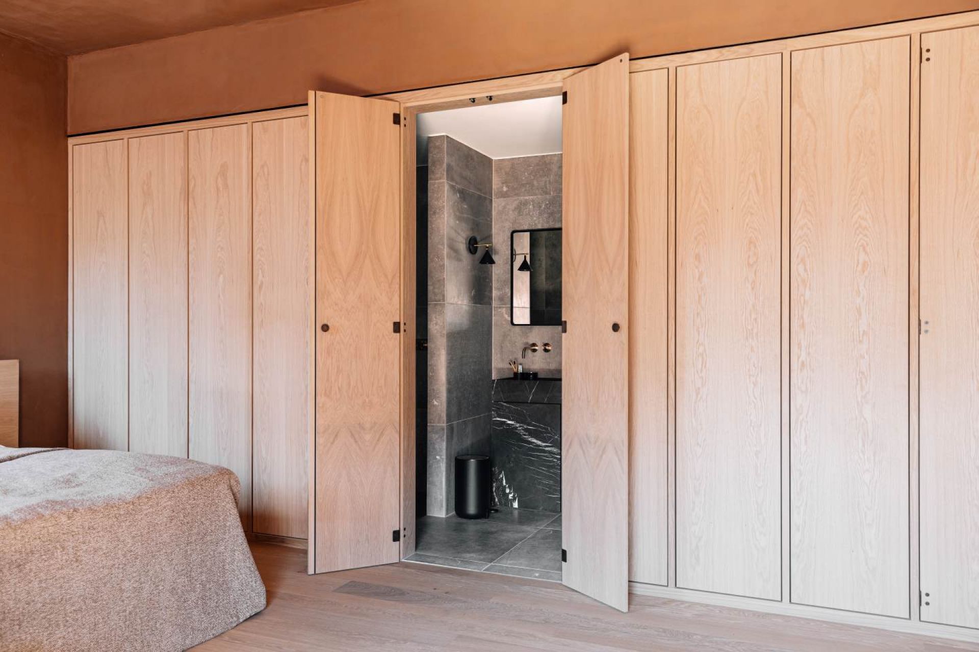 Badezimmer mit Audo Norm Wandspiegel rechteckig, montiert über einem modernen Marmorwaschtisch.