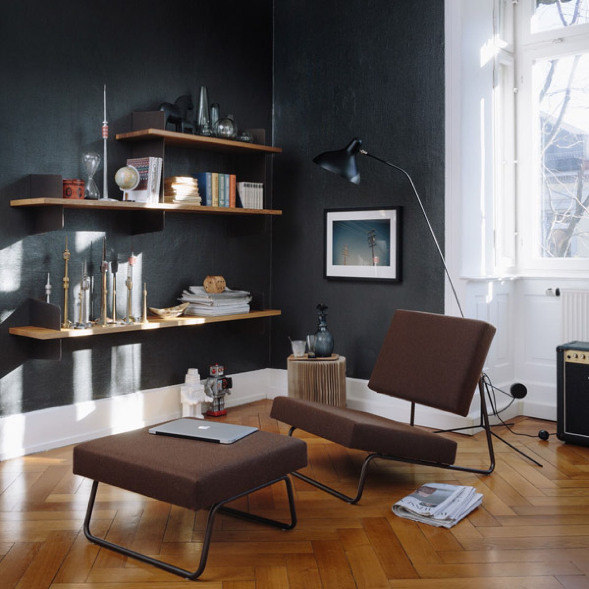 Brauner Lounge Chair mit Hocker von Richard Lampert in modernem Wohnzimmer mit dunkler Wand.