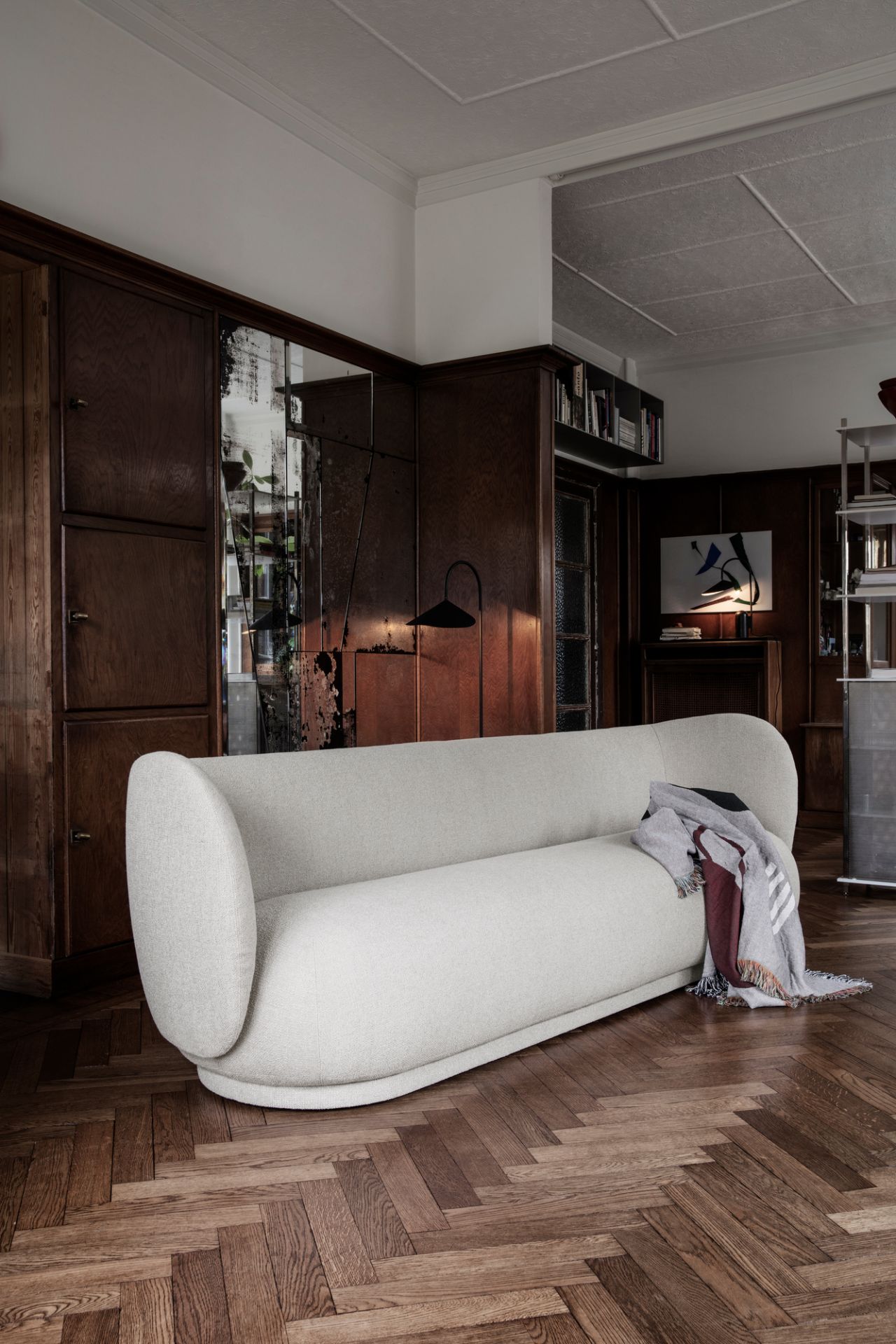 Arum Stehleuchte von Ferm Living im Wohnzimmer mit Sofa und dunkler Holzvertäfelung.