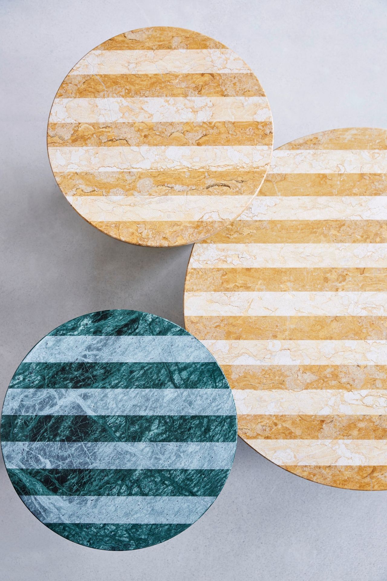 Drei runde Beistelltische aus Marmor, davon einer in Grün, mit Streifenmuster.