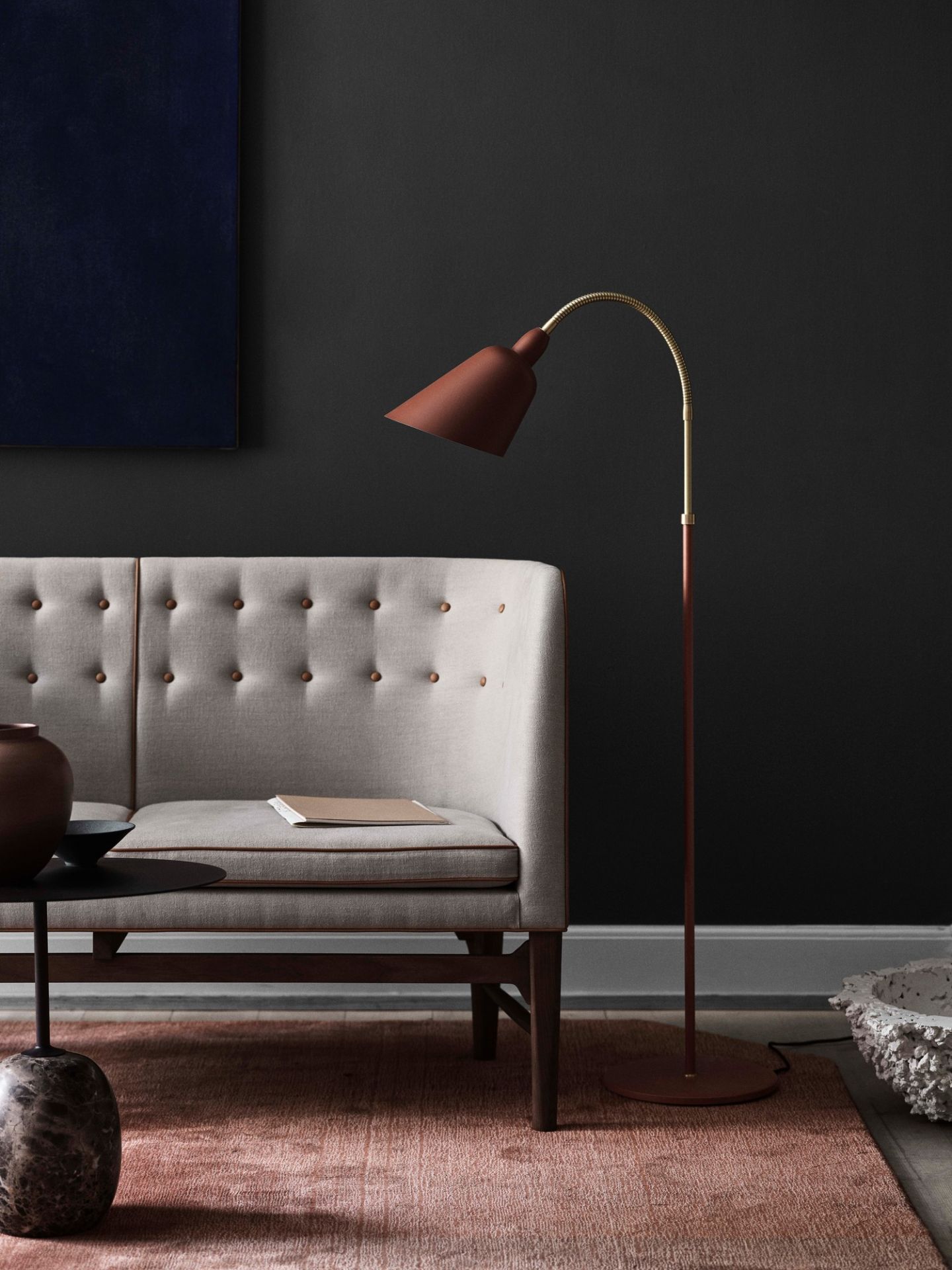 Beige Mayor Sofa von AndTradition mit Knopfleiste und brauner Stehlampe auf rosa Teppich.