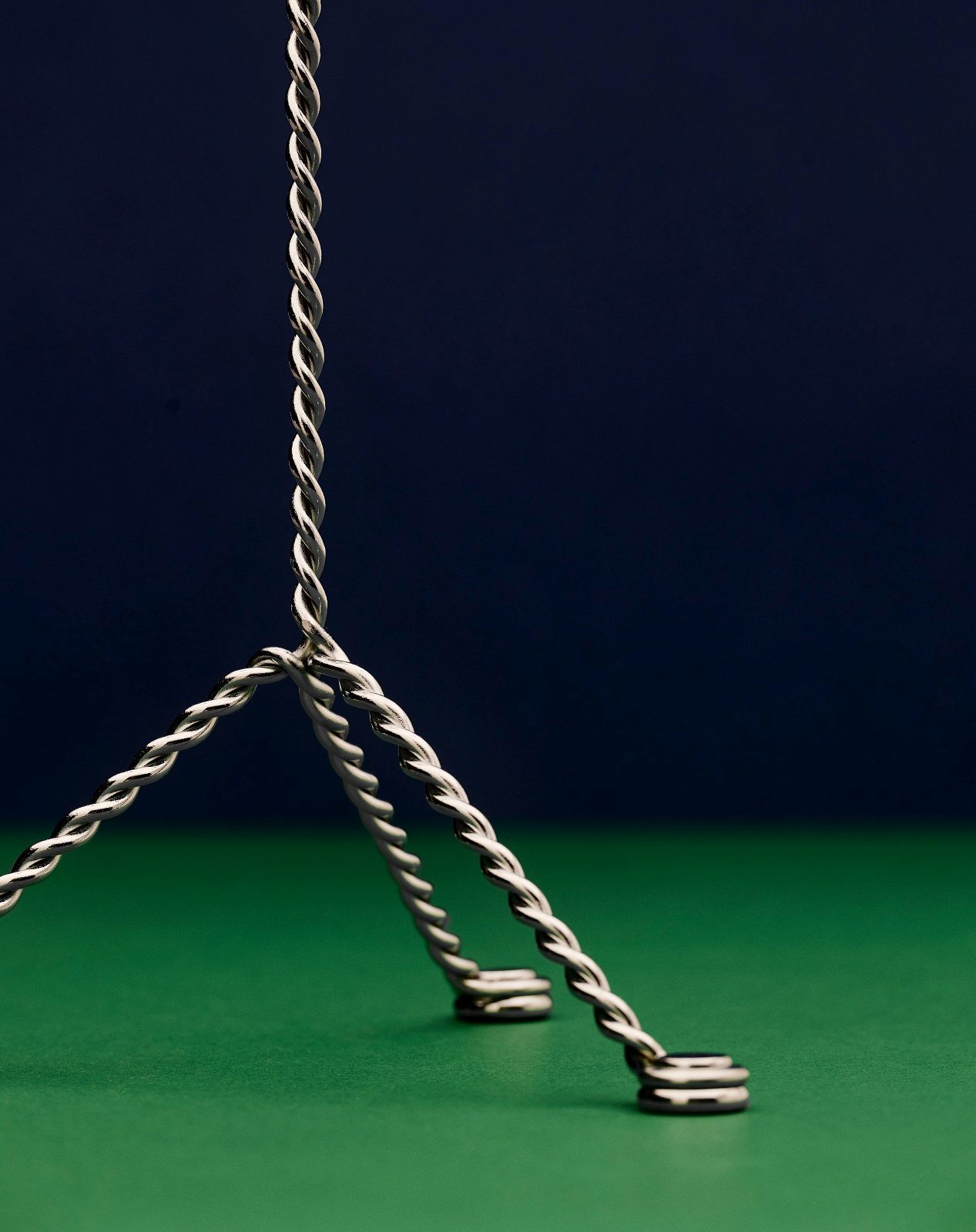 Detailaufnahme des Hay Wire Candleholder Kerzenständers aus silbernem Drahtgeflecht auf grünem Untergrund.