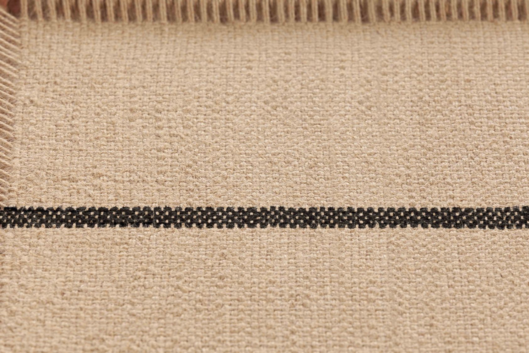 Detailaufnahme des Roots Single Stool Hocker 01 Gan mit beigem Stoff und schwarzem Streifen.