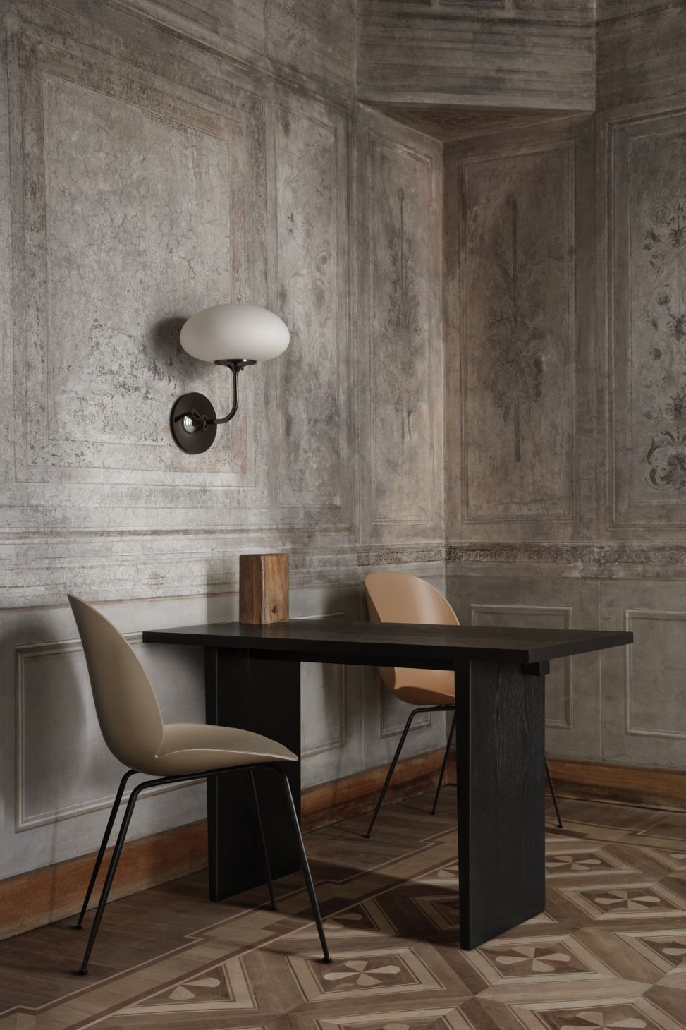 Gubi Private Desk Schreibtisch aus dunklem Holz mit zwei Stühlen in stilvollem Interieur.