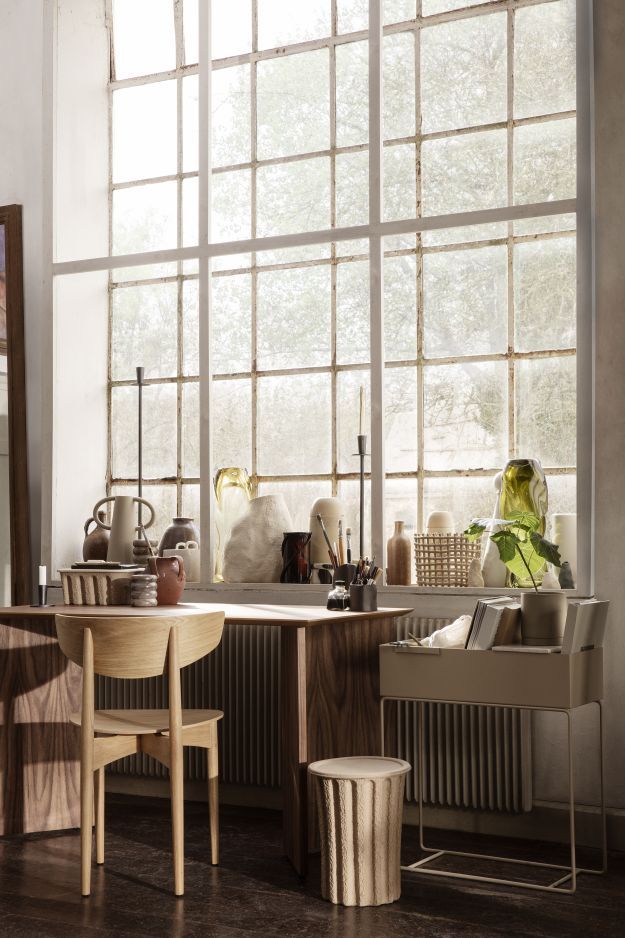 Ferm Living Mingle Table: Schreibtisch aus Holz mit Stuhl und Dekoration vor großem Fenster.