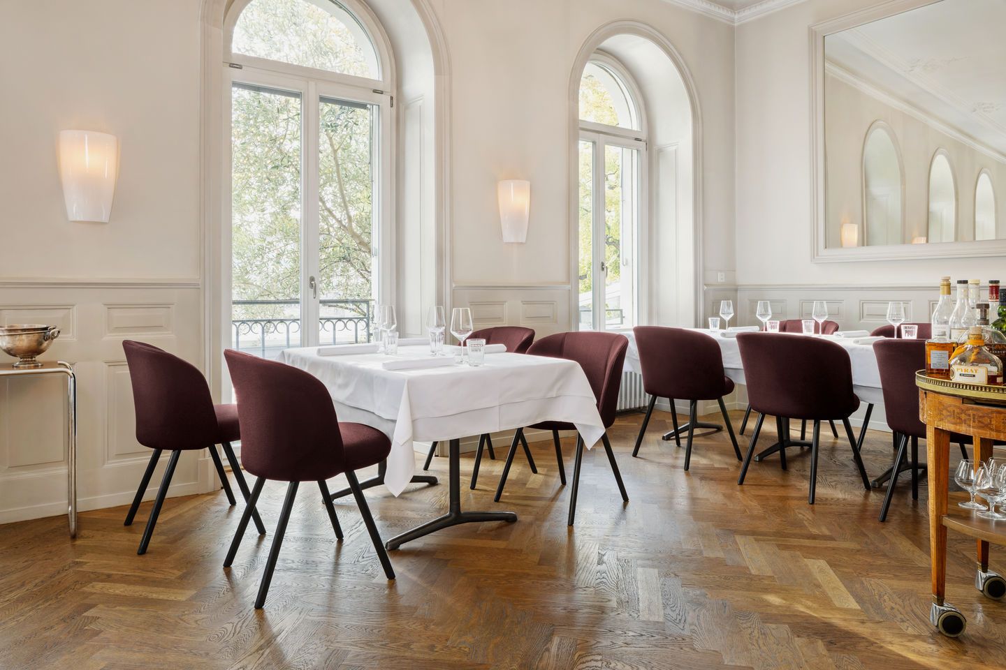 Innenaufnahme: Vitra Mikado Side Chair Stuhl, burgunderroter Polsterstuhl mit schwarzen Beinen, im Restaurant.