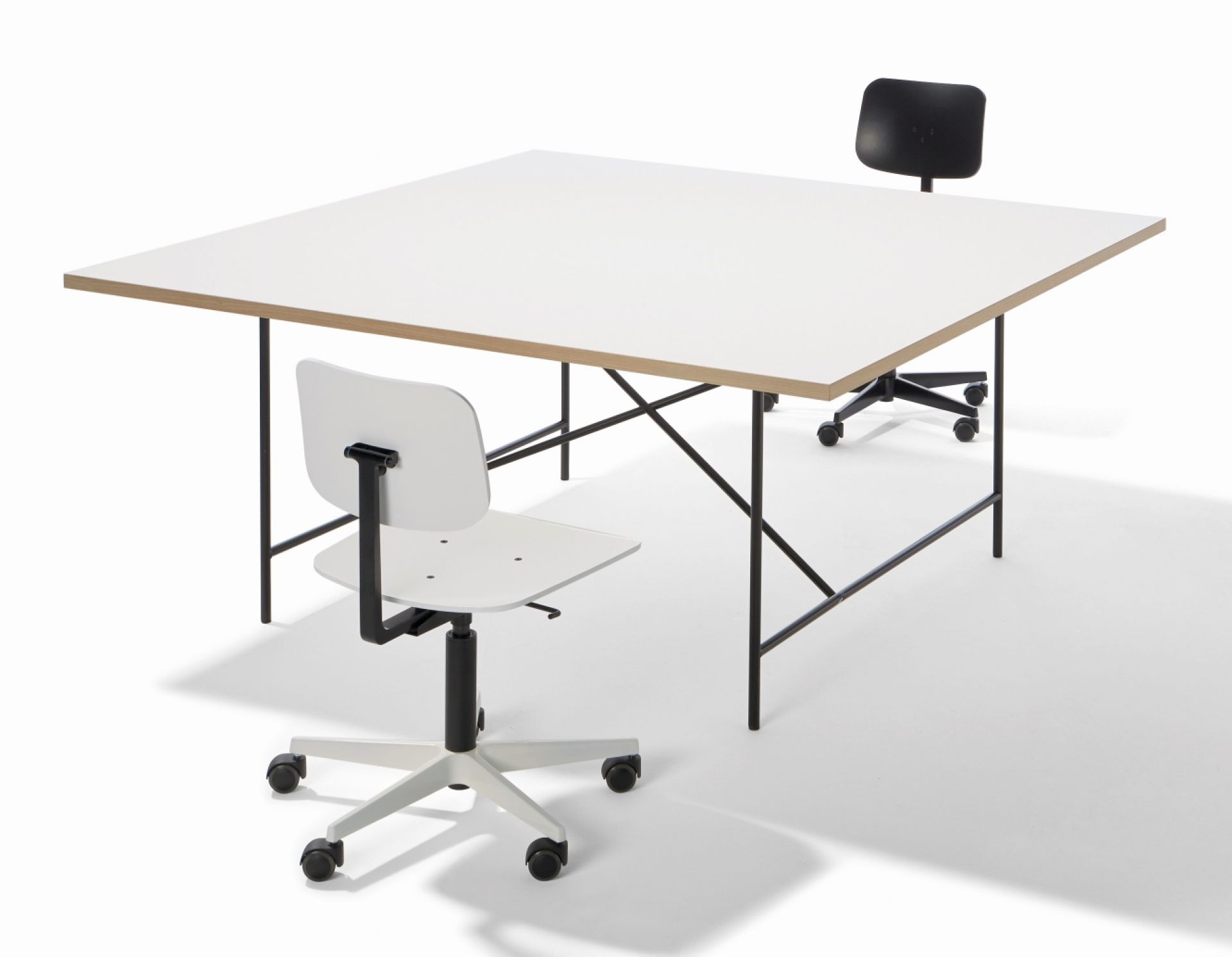 Quadratische, weiße Tischplatte für Eiermann Konferenztisch von Richard Lampert mit schwarzem Tischgestell und zwei Bürostühlen.