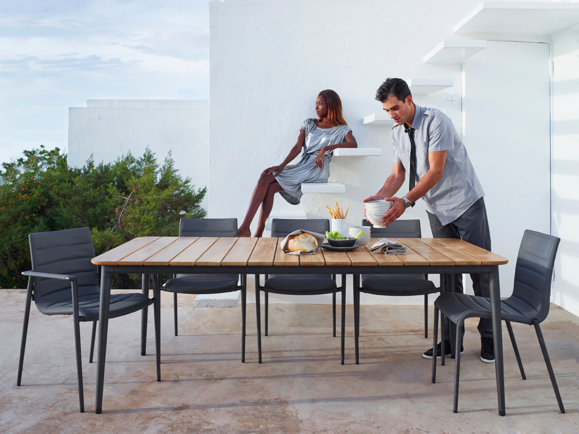 Core Outdoor Esstisch aus Teak von Cane-Line mit grauen Stühlen für stilvolles Essen im Freien.