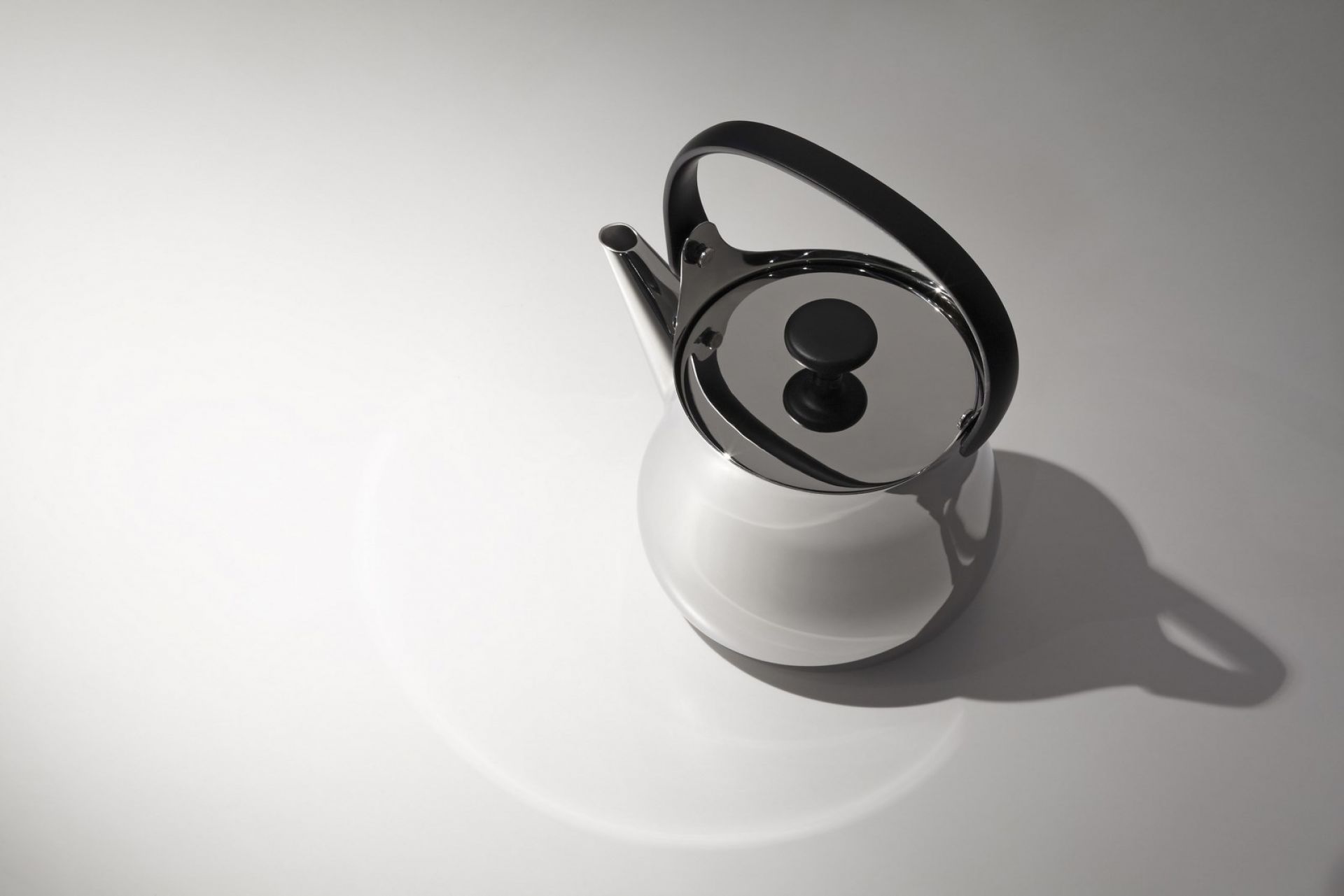 Nahaufnahme der Alessi Cha Teekanne: Edelstahl, schwarzer Griff und Deckel, modernes Design.