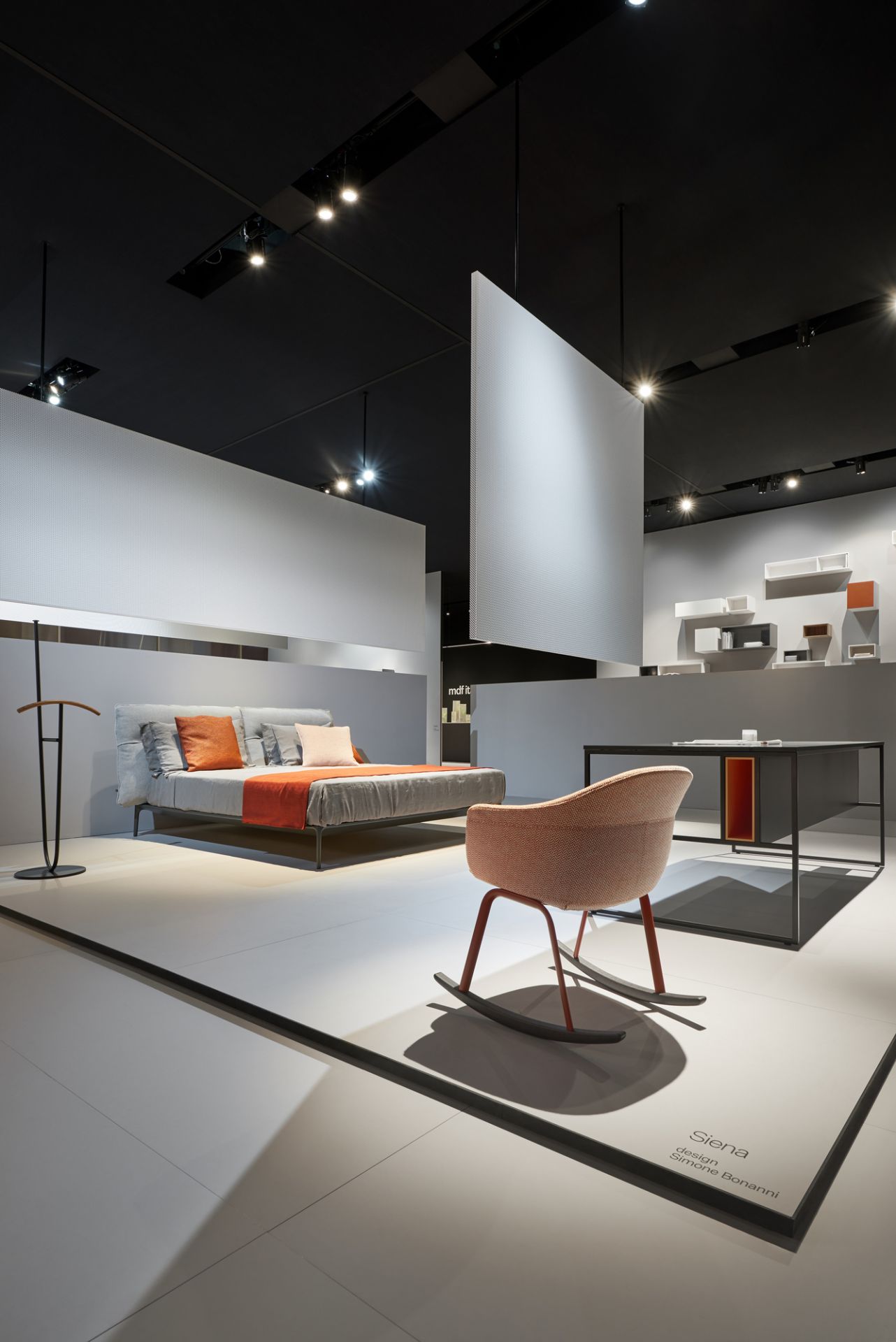 Modernes Schlafzimmer-Interieur mit MDF Italia Ombre Stummer Diener, Bett, Schreibtisch und Schaukelstuhl in minimalistischem Design.