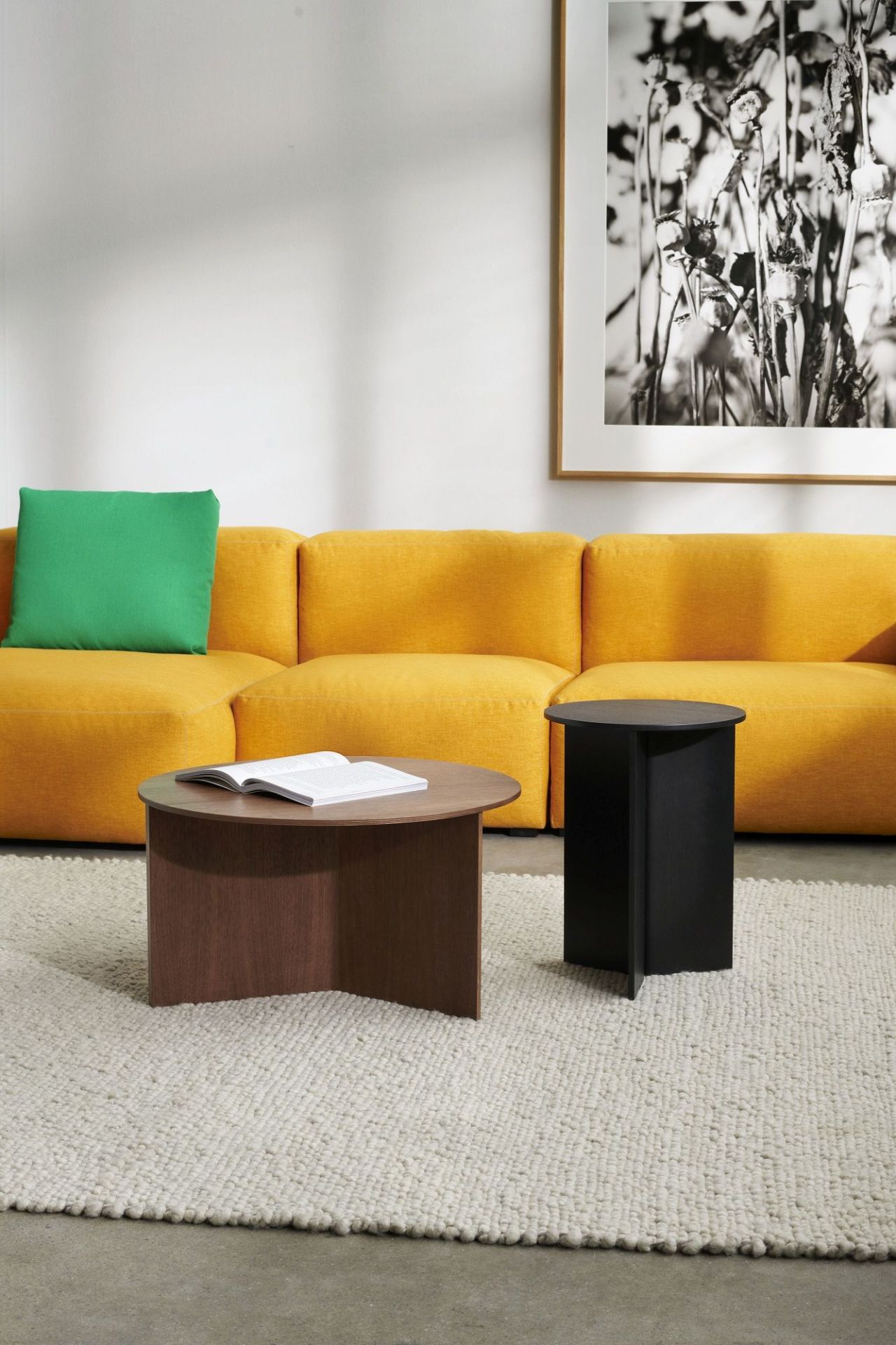 Hay Slit Table Wood Round High Beistelltisch in Schwarz und Braun vor gelbem Sofa.