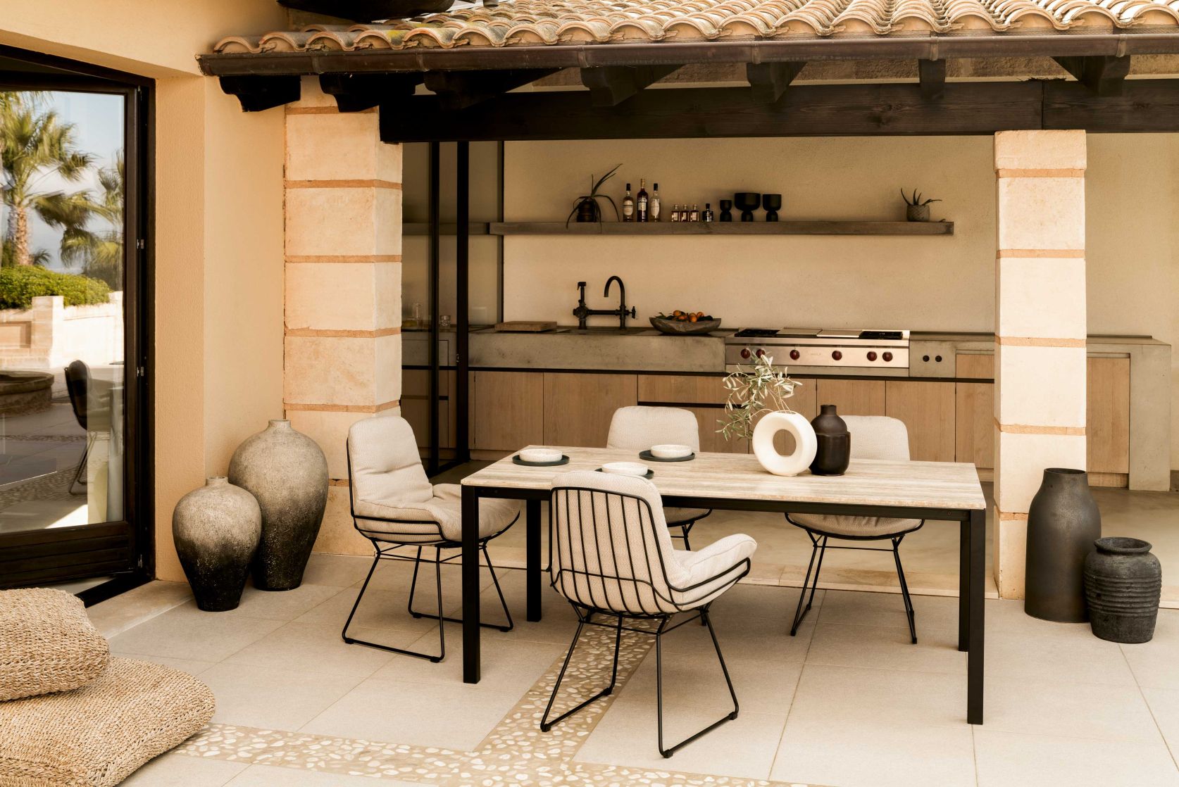 S 600 Outdoor Tisch mit Steinplatte von Janua in stilvollem Ambiente mit Außenküche.