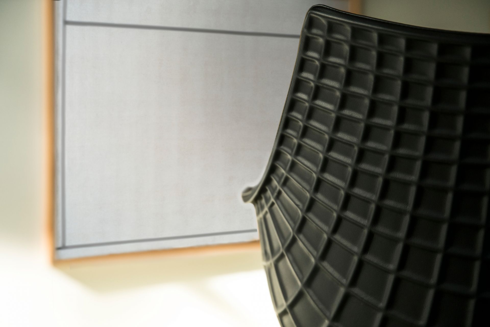 Detailaufnahme des schwarzen Meridiana Armlehnstuhls mit Lederbezug und markantem Rautenmuster. Designermöbel für stilvolles Wohnen.