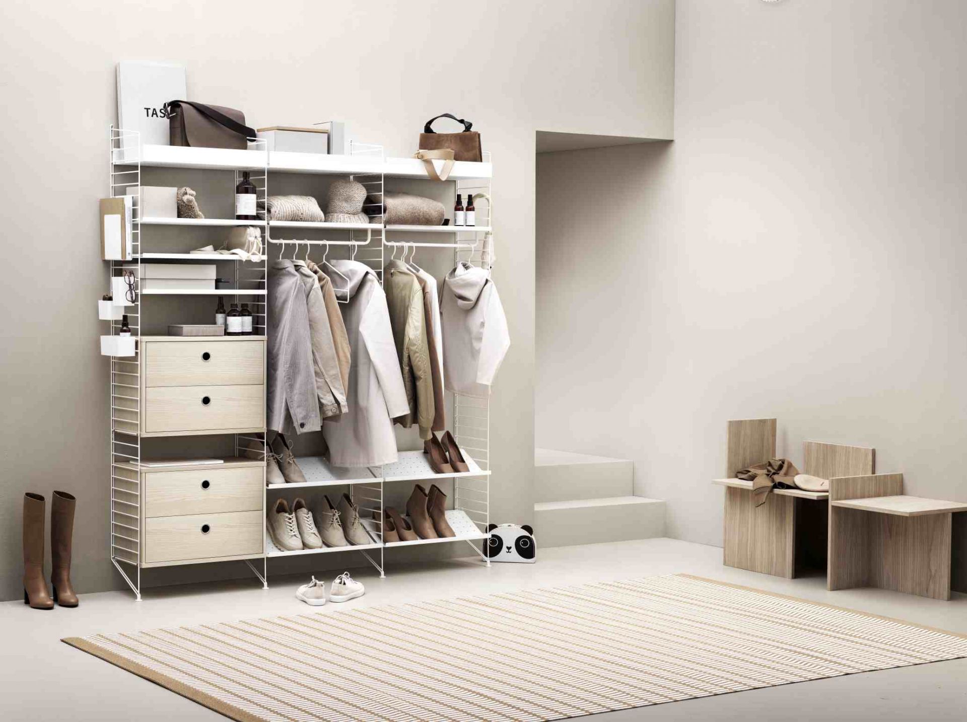 Weißes String Regalsystem im Schlafzimmer mit Kleidung, Schuhen und Kommode. String Furniture für Ordnung.