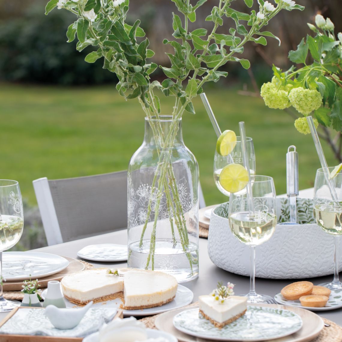 Living Glasvase mit Blumen auf gedecktem Tisch im Garten, dekorative Blumenvase.