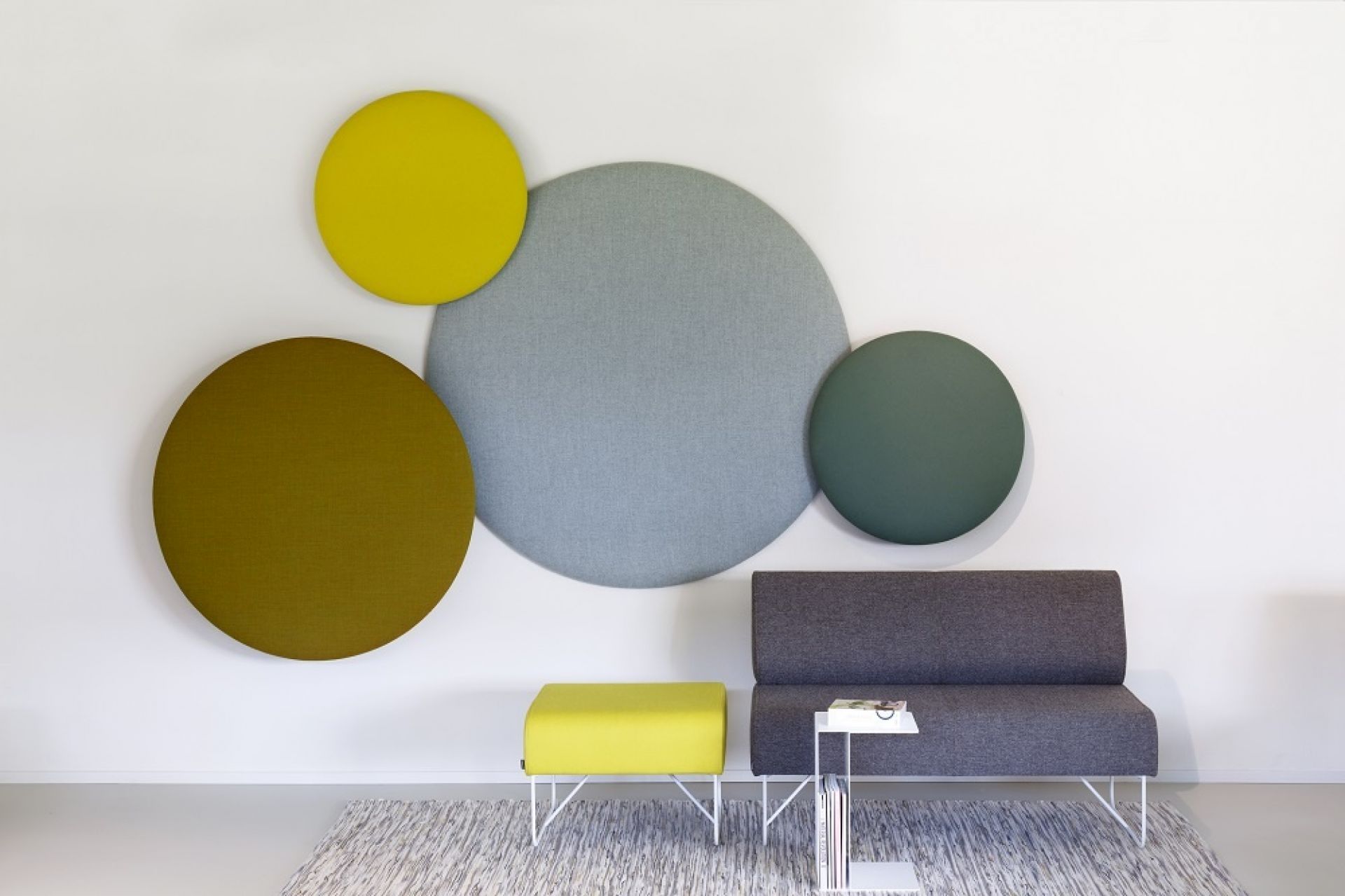 Pillow Round Wandpaneele von Cascando: Runde Akustikelemente in Gelb, Grau und Olivgrün an der Wand.