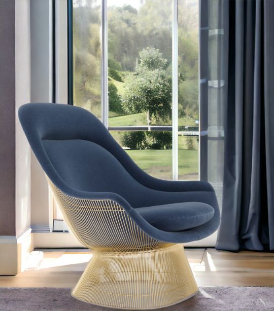Blauer Platner Sessel von Knoll International mit goldfarbenem Drahtgestell vor Fenster. Designklassiker.