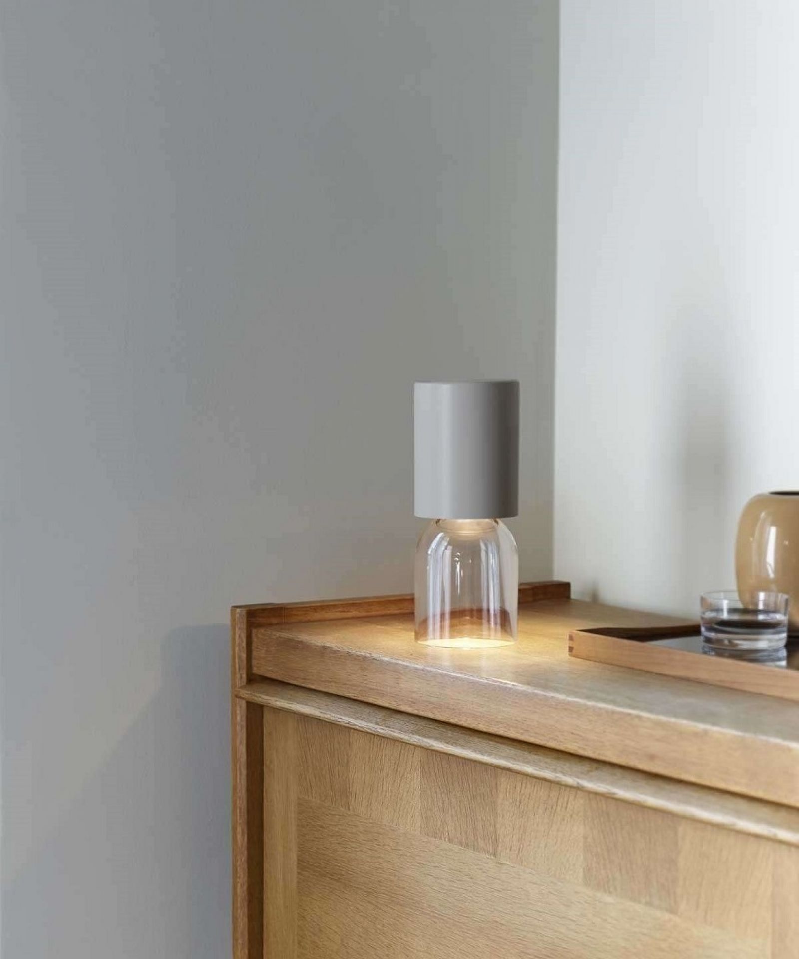 A02R1 NUI Akkuleuchte von Luceplan auf Holzkommode, tragbare Tischleuchte für Innen und Außen.