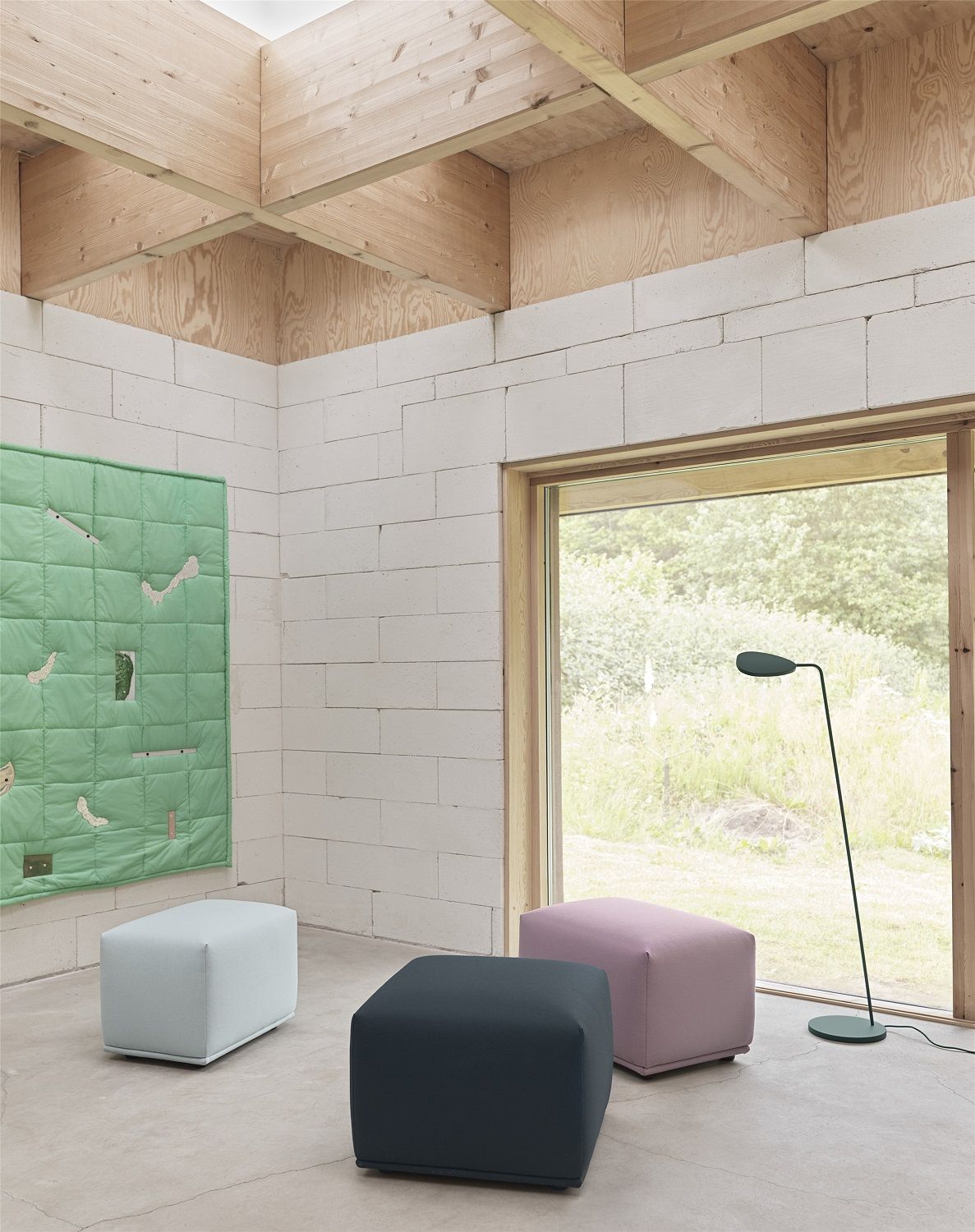 Drei farbige Muuto Pouf Hocker im Raum, moderne Sitzmöbel und stilvolle Wohnaccessoires.