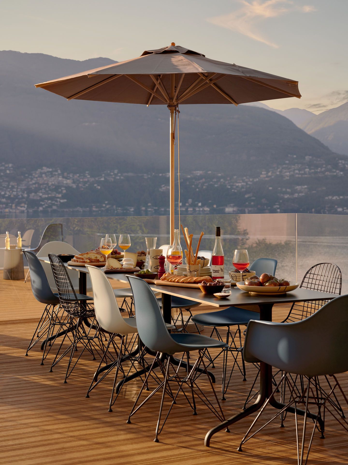 Esstisch im Freien mit Eames Plastic Armchair (DAR) Stühlen von Vitra, verschiedene Farben.