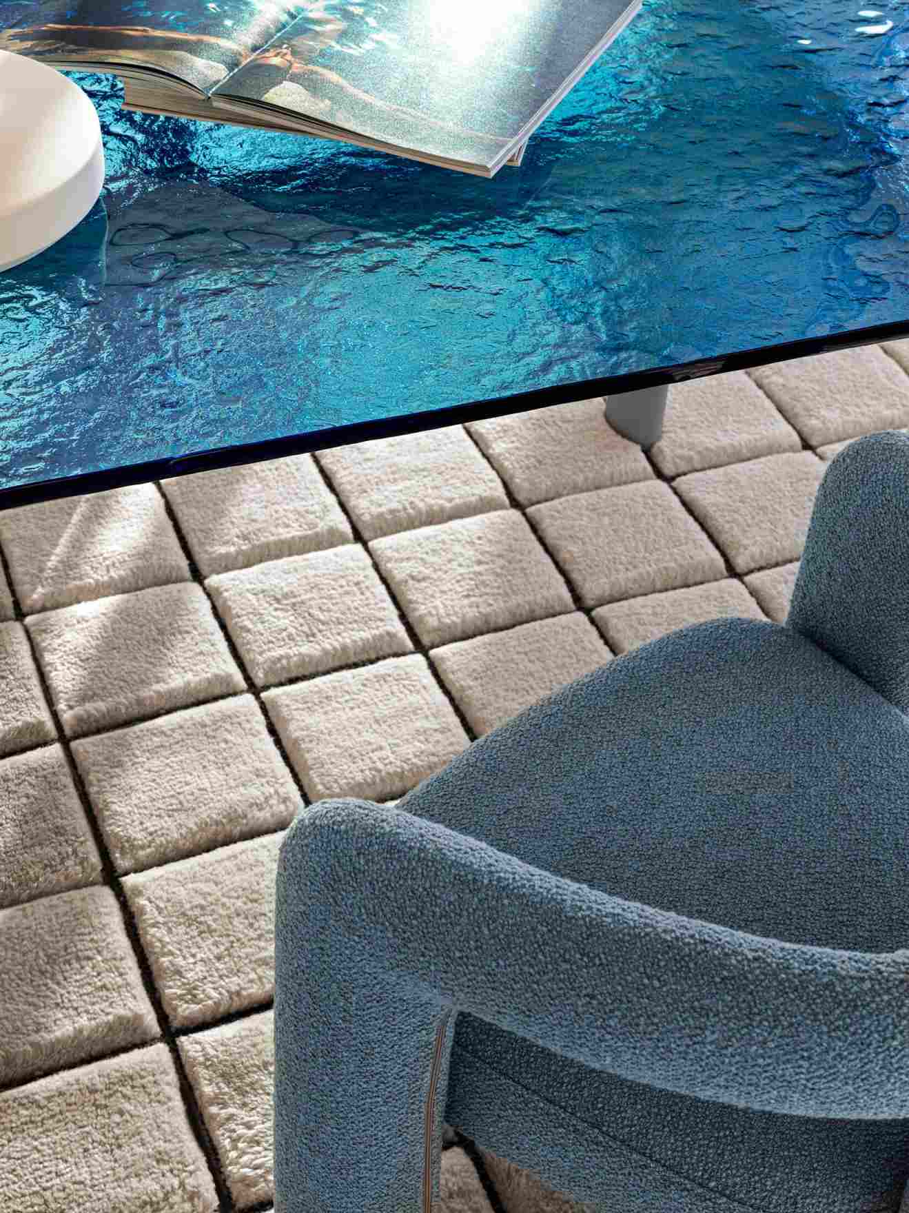 Nahaufnahme des LC6 Table tube d´avion Esstisches Cassina mit blauer Glasplatte und Teppich.