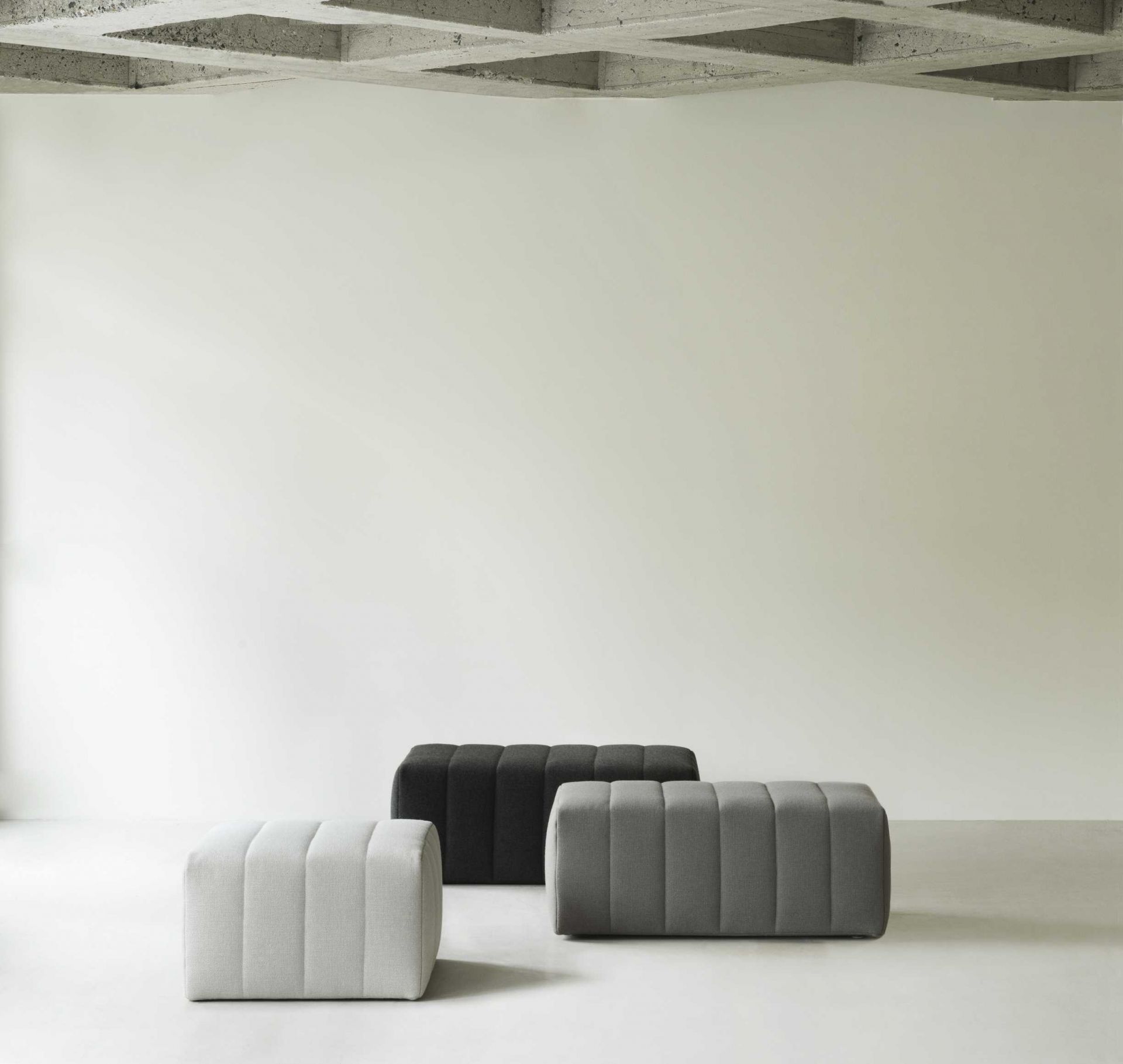 Drei Scene Pouf Hocker von Normann Copenhagen in Grau und Schwarz auf hellem Untergrund.