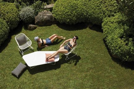 Draufsicht: Zwei Frauen entspannen auf Fermob Sixties Outdoor Sesseln und einem passenden Tisch im Garten.