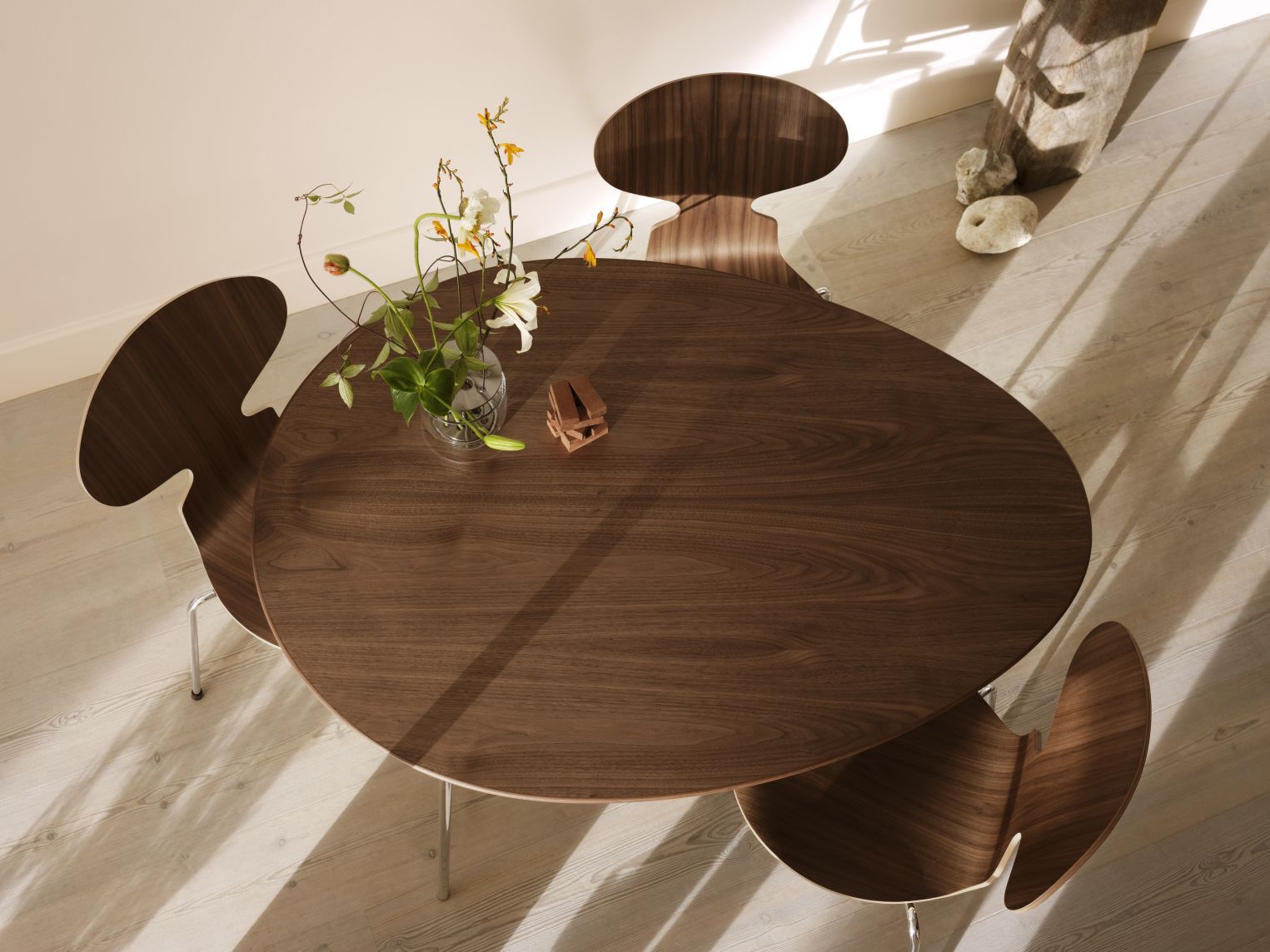 Ansicht von oben: Runder Egg Table Tisch von Fritz Hansen mit Holzstühlen und Blumenvase.
