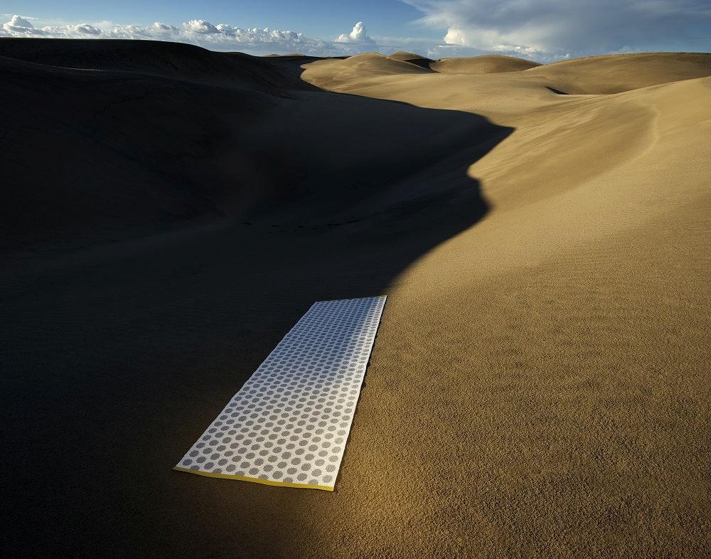 Noa Kunststoffteppich Pappelina in Pale türkis in der Wüste. Moderner Teppich für Innen und Außen.