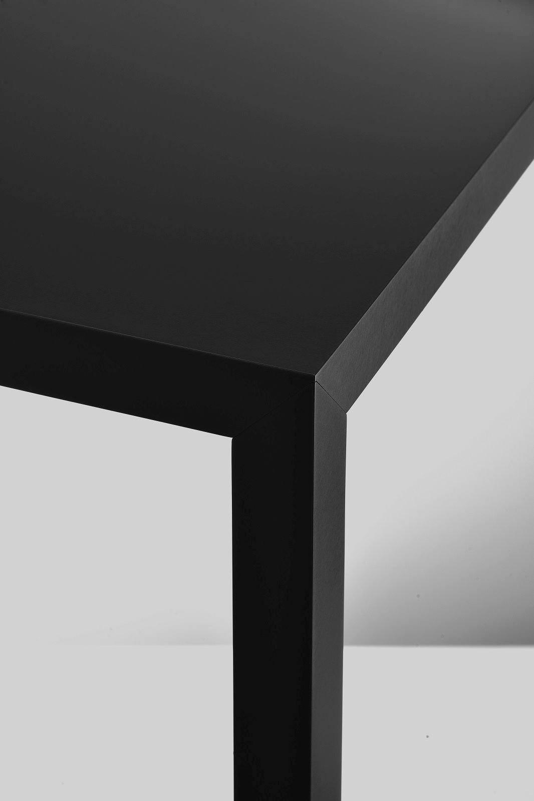 Detailaufnahme vom Tense Esstisch von MDF Italia, schwarze Tischplatte und Tischbein, minimalistisches Design.