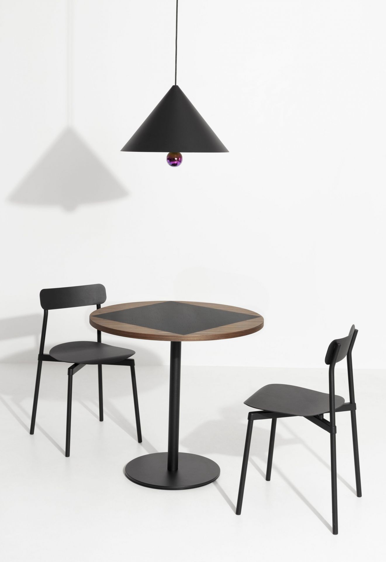 Cherry Pendelleuchte von Petite Friture in Schwarz über Esstisch mit zwei Stühlen.