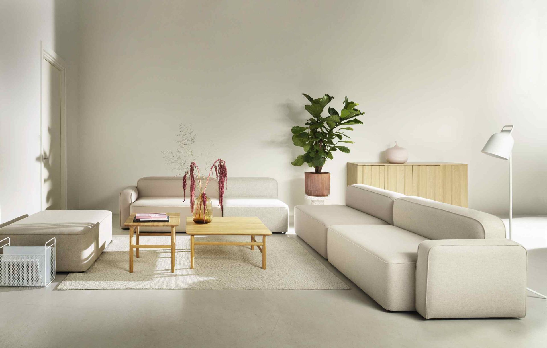 Wohnzimmer mit modularem Sofa und Grow Table Couchtisch von Normann Copenhagen in hellem Holz.