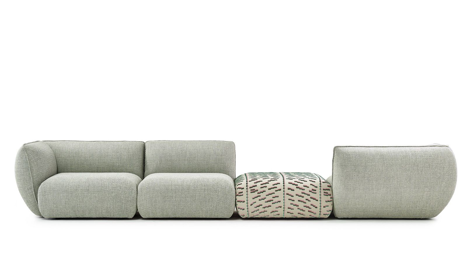 Mia Modular Sofa von Freifrau: Kombinationsvorschlag mit hellgrauem Stoff und gemustertem Hocker. Moderne Wohnzimmergestaltung.