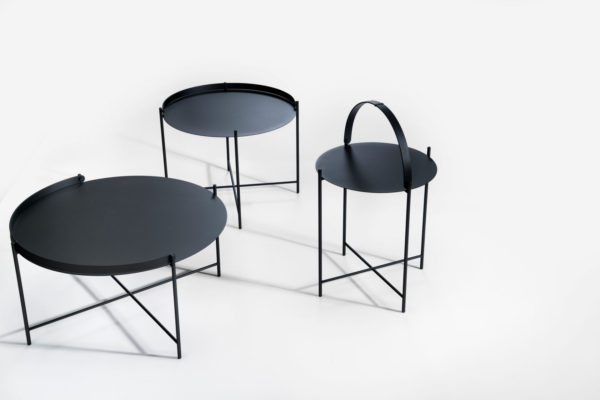 Drei schwarze Edge Tray Table Beistelltische von Houe auf weißem Hintergrund, verschiedene Höhen und Designs.