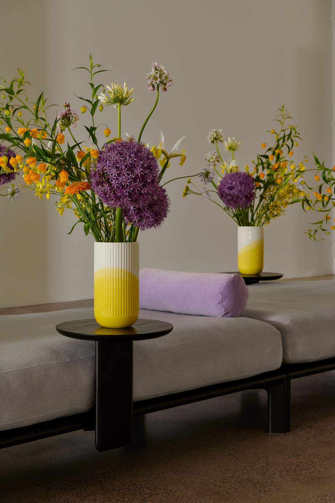 Anagram Anstecktisch von Vitra, runde Tischplatte in Schwarz, mit Blumenvasen dekoriert, modernes Möbeldesign.