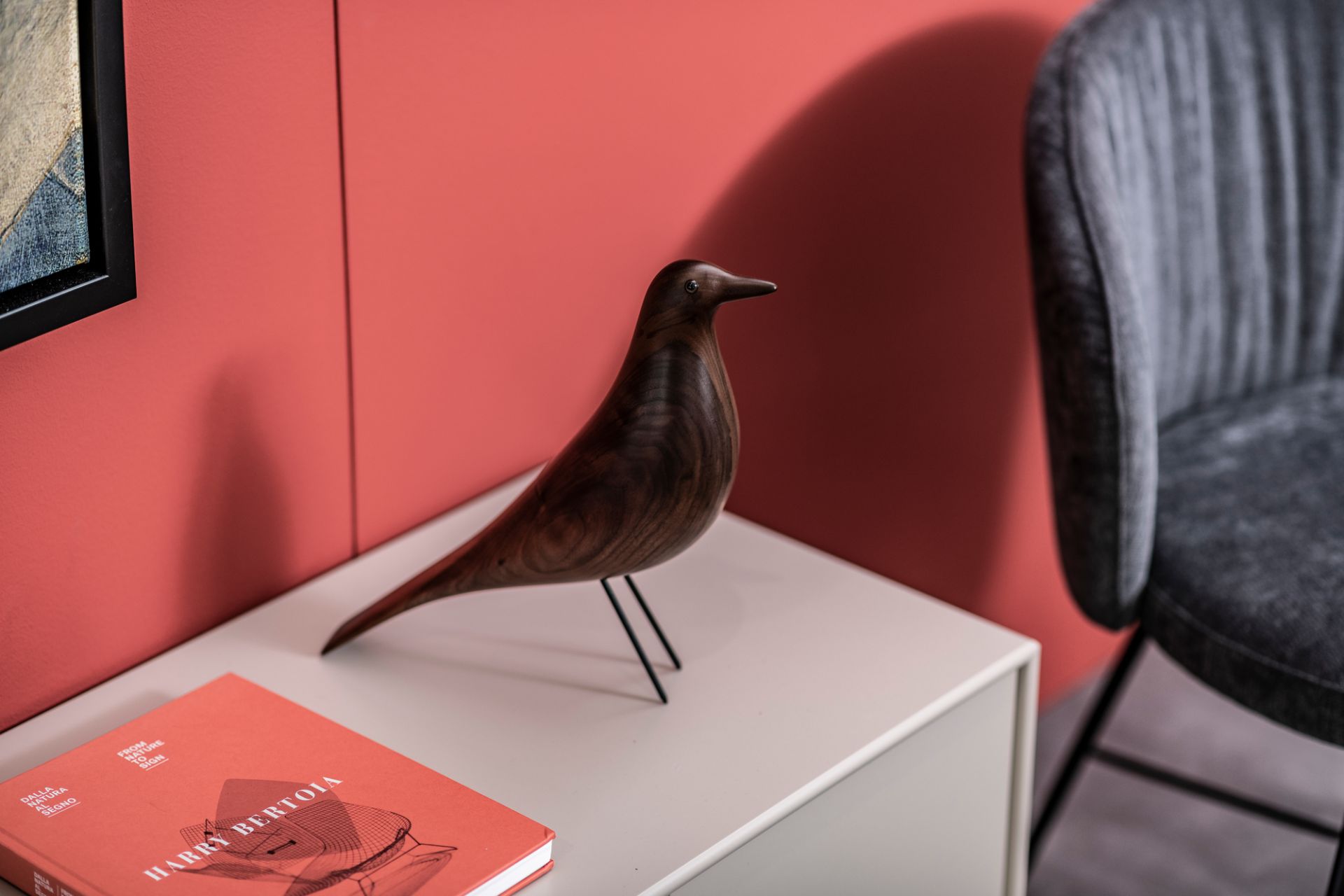 Eames House Bird Skulptur aus Nussbaum von Vitra auf einem Nachttisch, modernes Wohndesign.