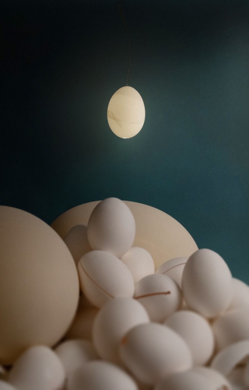 Reality Pendelleuchte von Ingo Maurer, eiförmige Hängelampe über einer Ansammlung von Eiern.