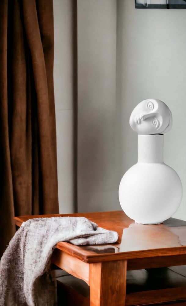 Weiße Luna Vase mit Gesichts-Design auf Holzmöbel, dekorative Keramik Vase für modernes Wohnambiente.